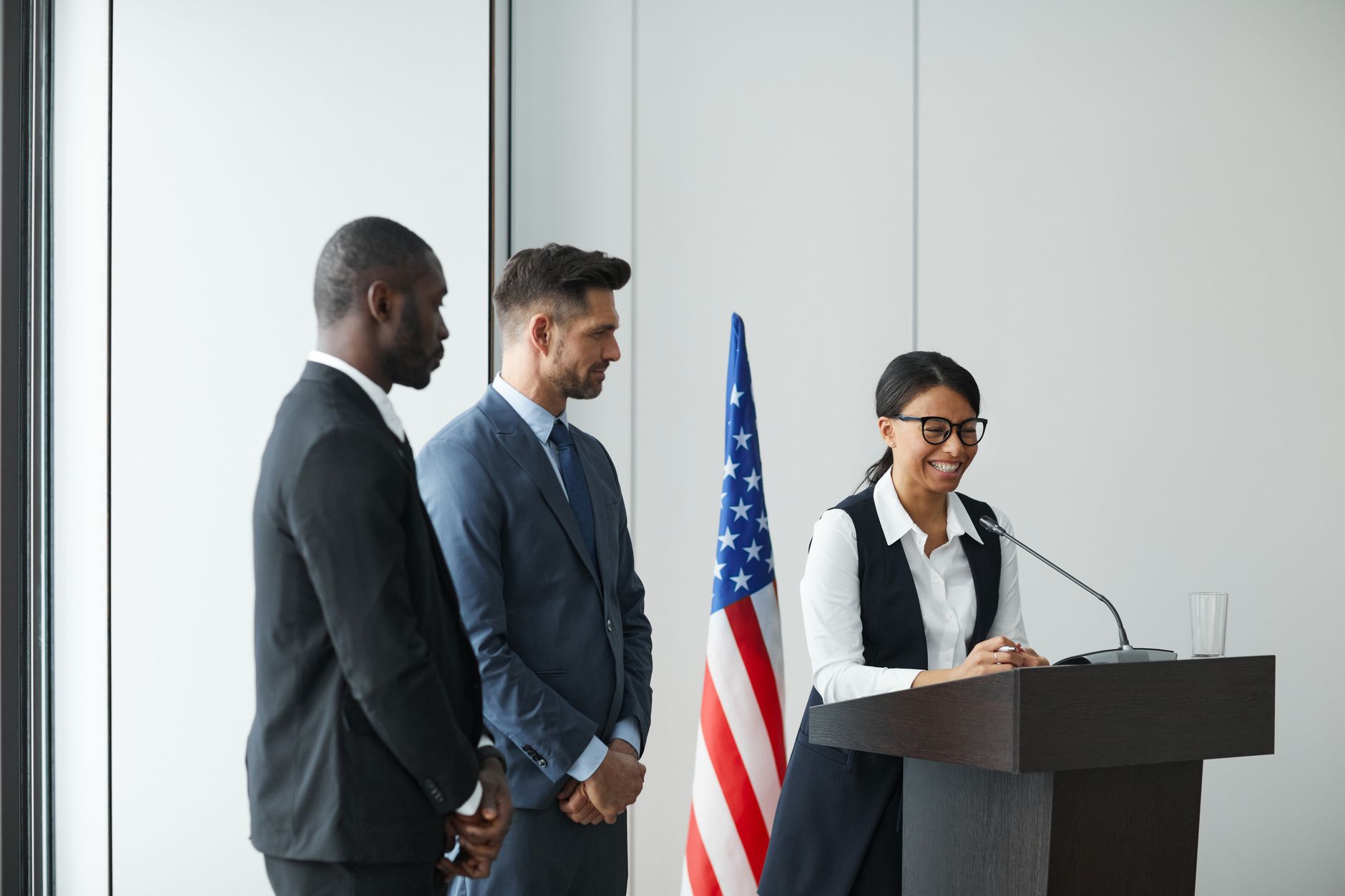 A diverse team in business attire at a podium with an American