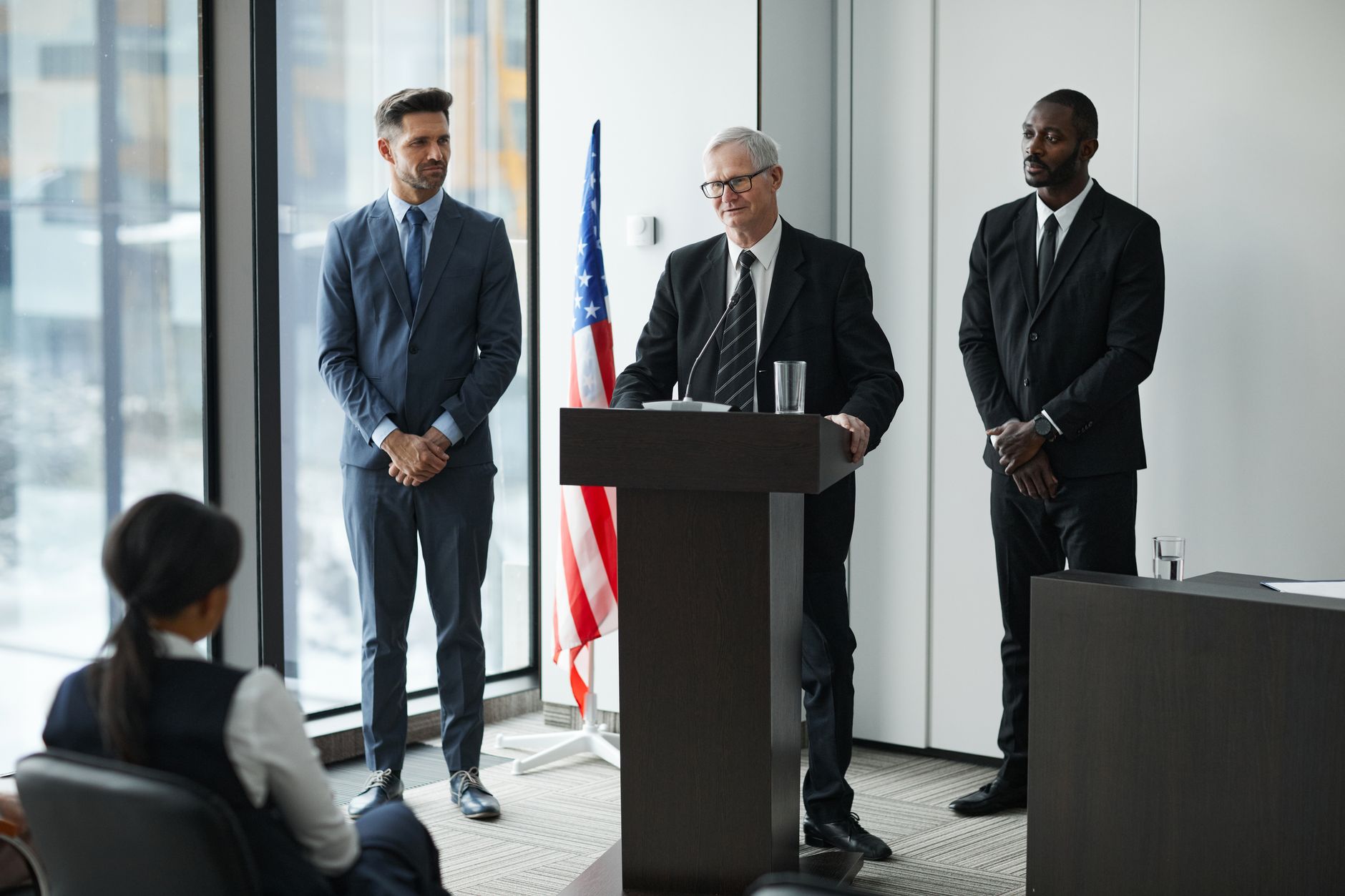 Officials delivering a political speech in a modern conference room with an