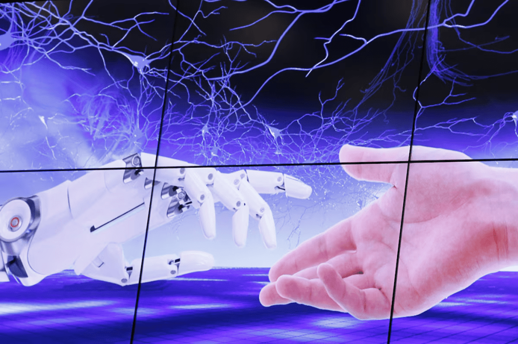 An illustration projected on a screen shows a robot hand and a