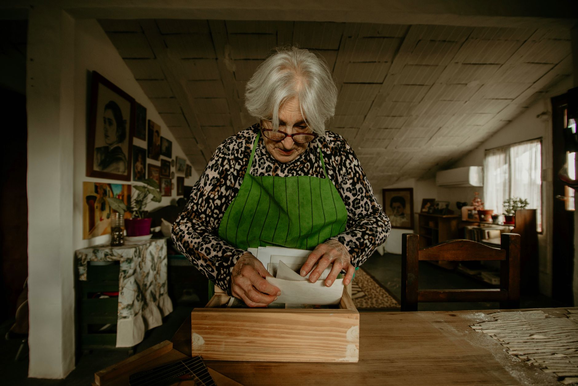Senior woman wearing apron, organizing recipe cards in her cozy kitchen.