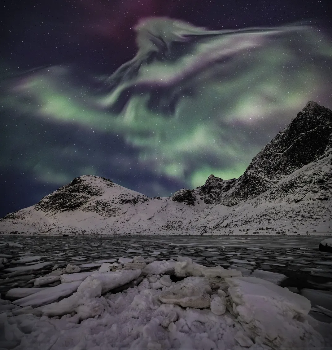 green auroras over icy mountains