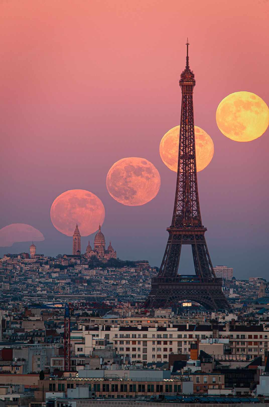 Pinkish time-lapse of the moon crossing over the Paris skyline