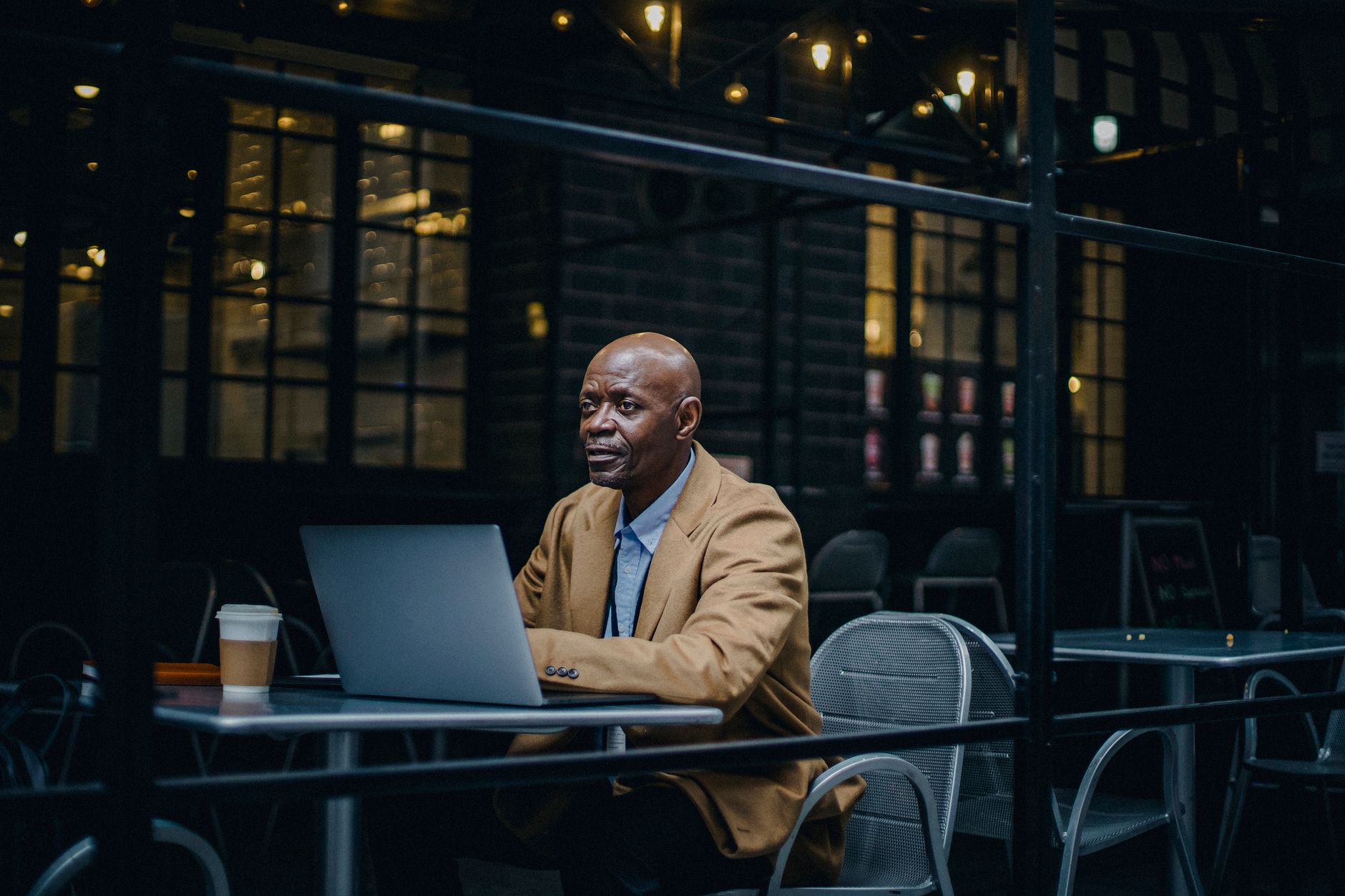African American man in a cafe working on laptop, enjoying a coffee,