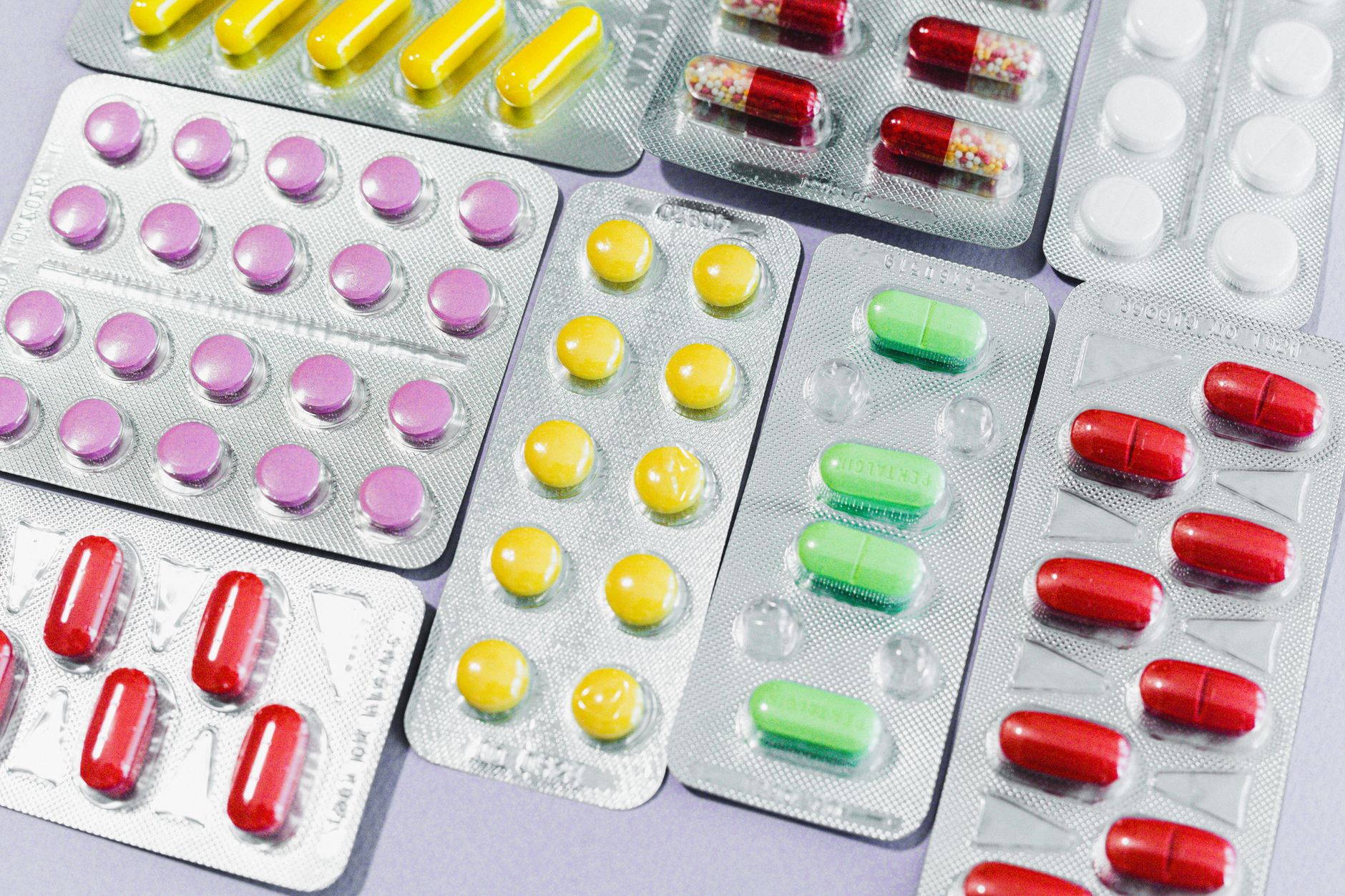 A variety of colorful pills and tablets in blister packs, representing diverse