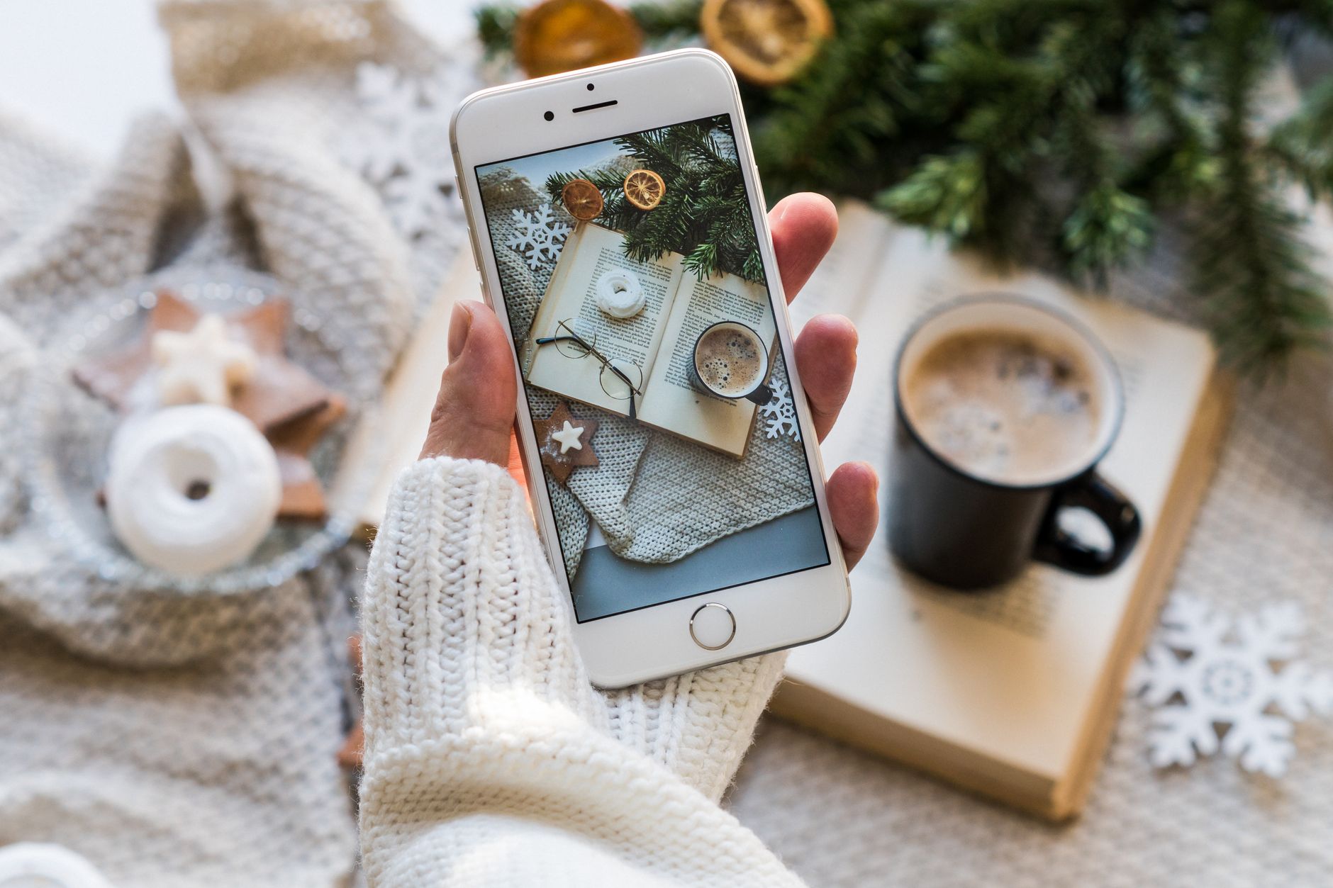 Top view of cozy winter setting with coffee, smartphone capturing a warm