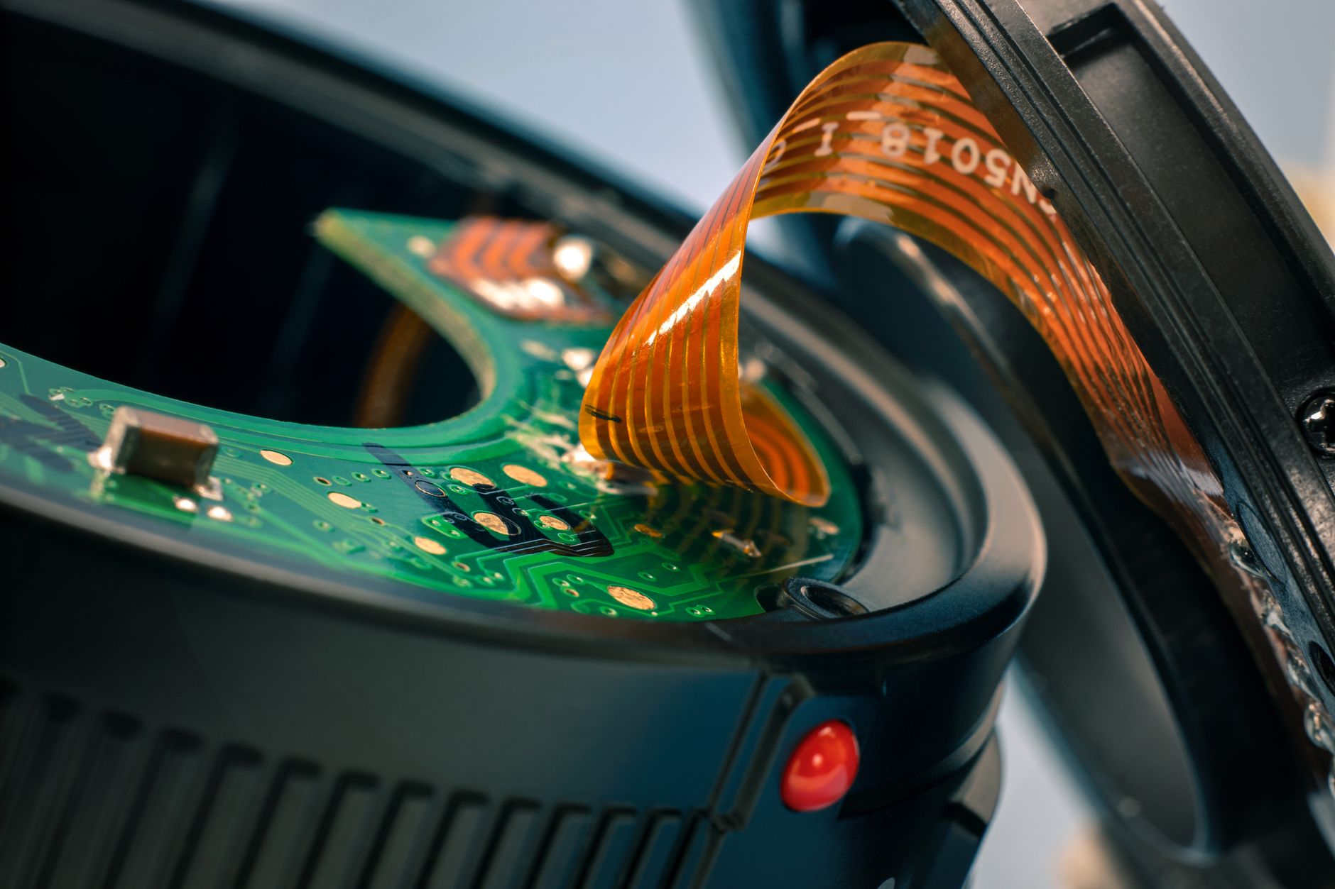 Detailed close-up of circuit board and ribbon cable in a disassembled camera