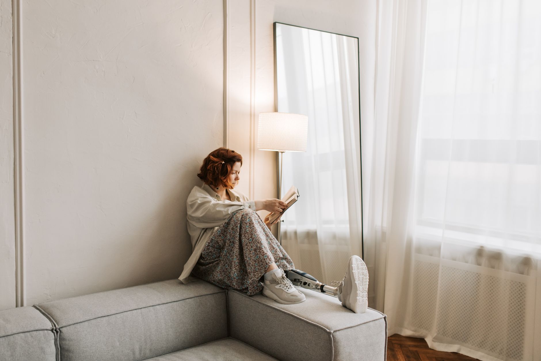 A woman with a prosthetic leg enjoys reading while sitting on a