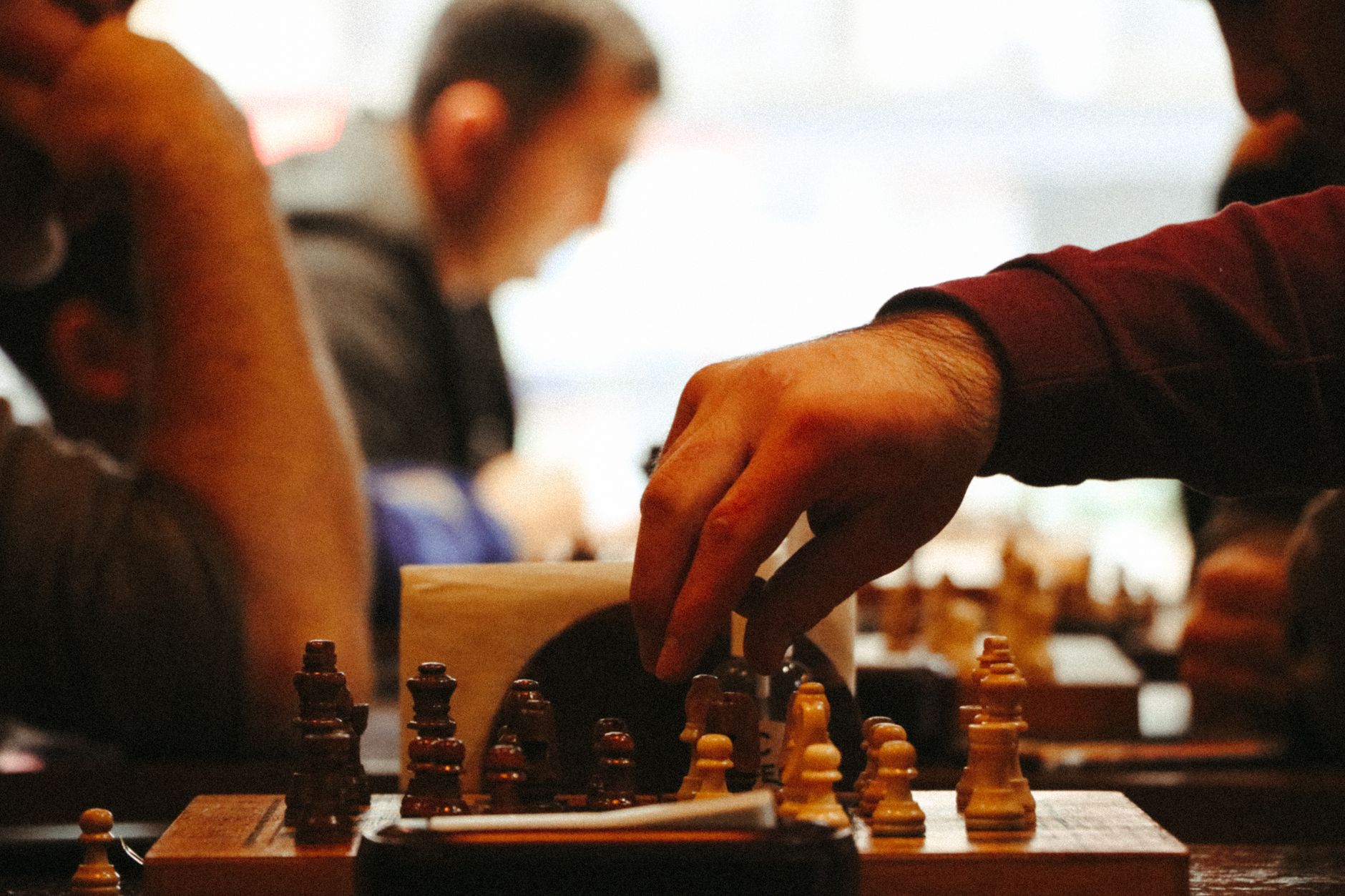 Close-up of a hand moving a chess piece during an intense game.