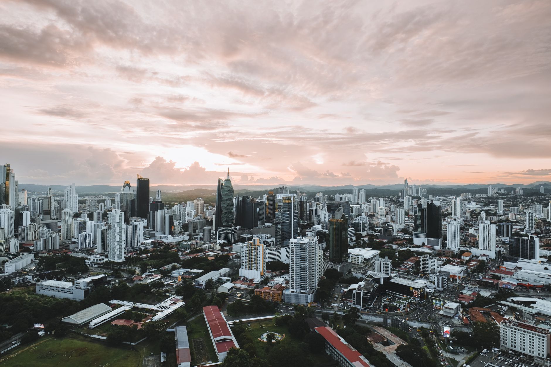 Dramatic aerial view of Panama City skyline during sunset showcasing modern skyscrapers.