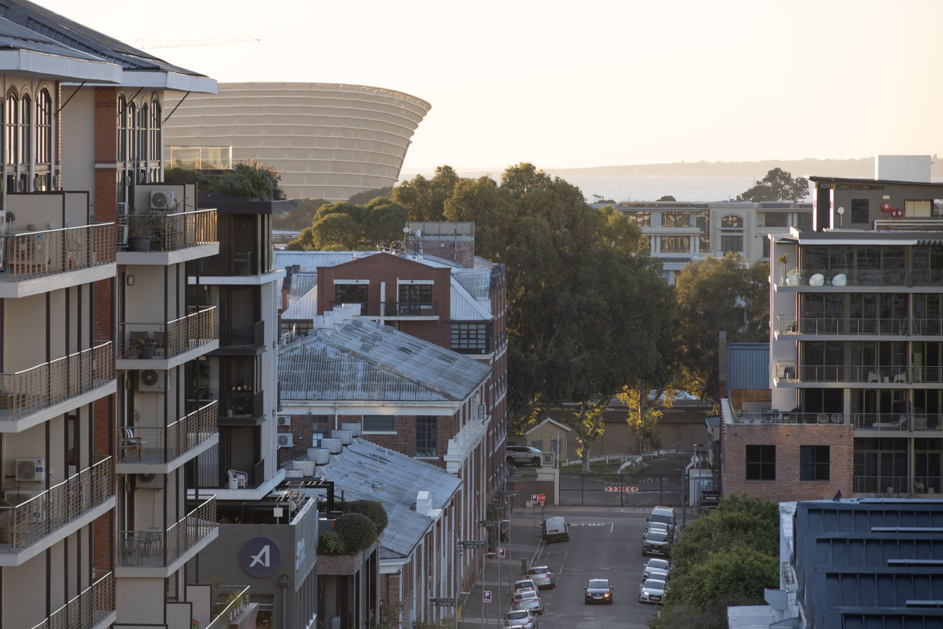 Cityscape view featuring modern architecture and Cape Town Stadium in morning light.