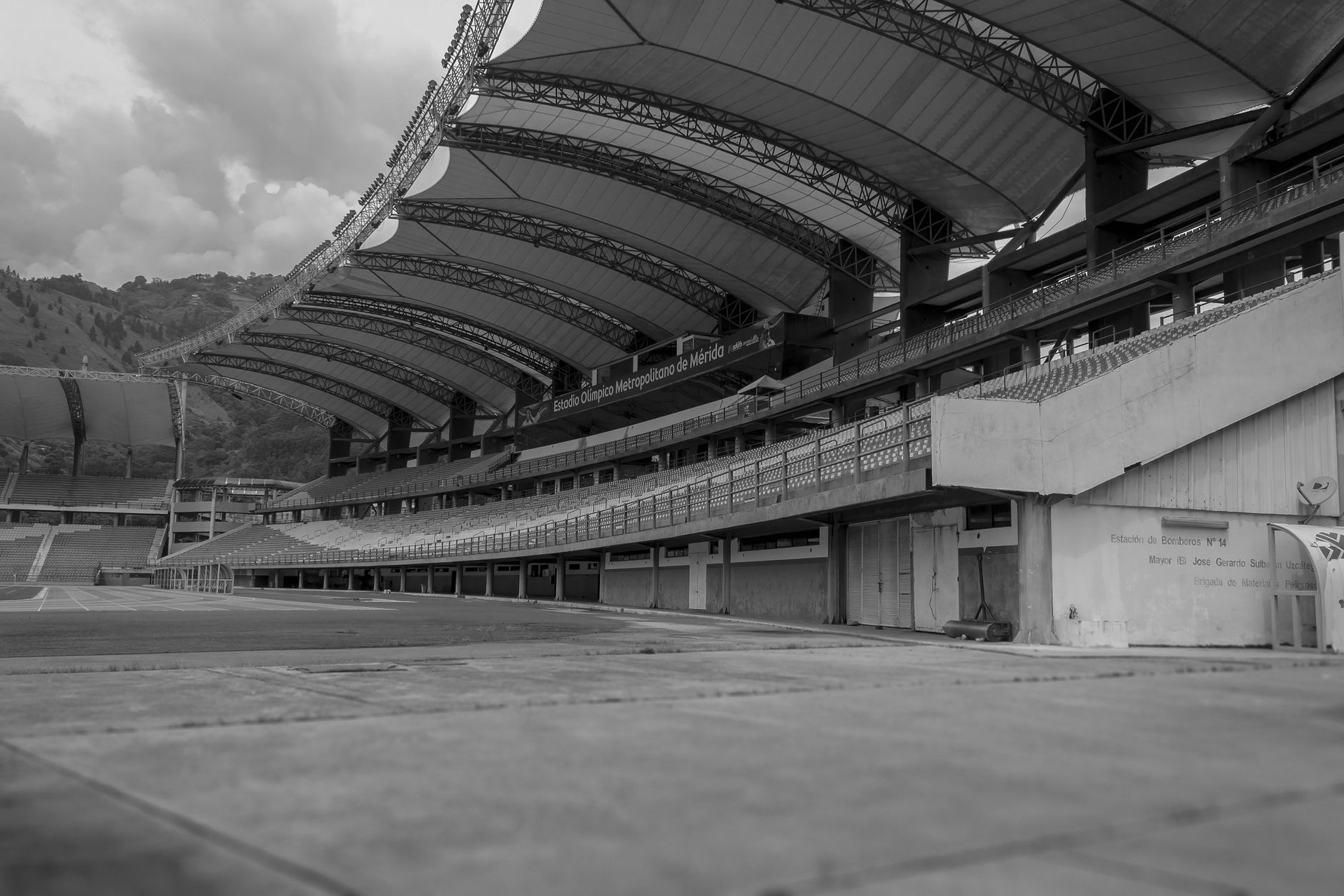 Monochrome view of an empty football stadium featuring modern architecture and expansive