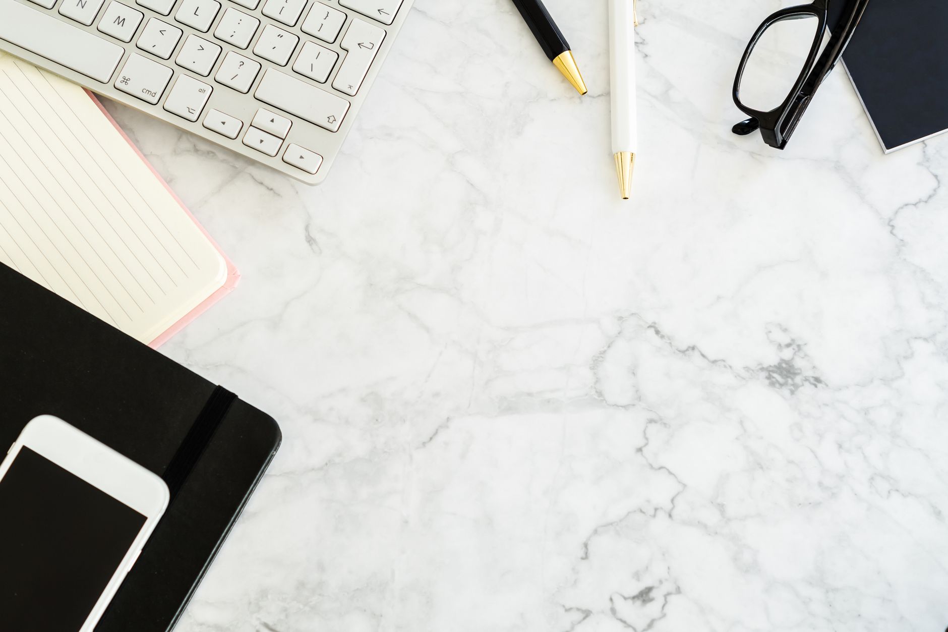 Flat lay of a modern office desk with gadgets and stationery on
