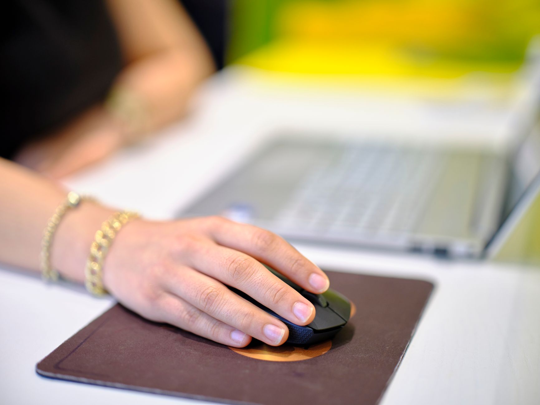 A person using a wireless mouse at a desk, perfect for business