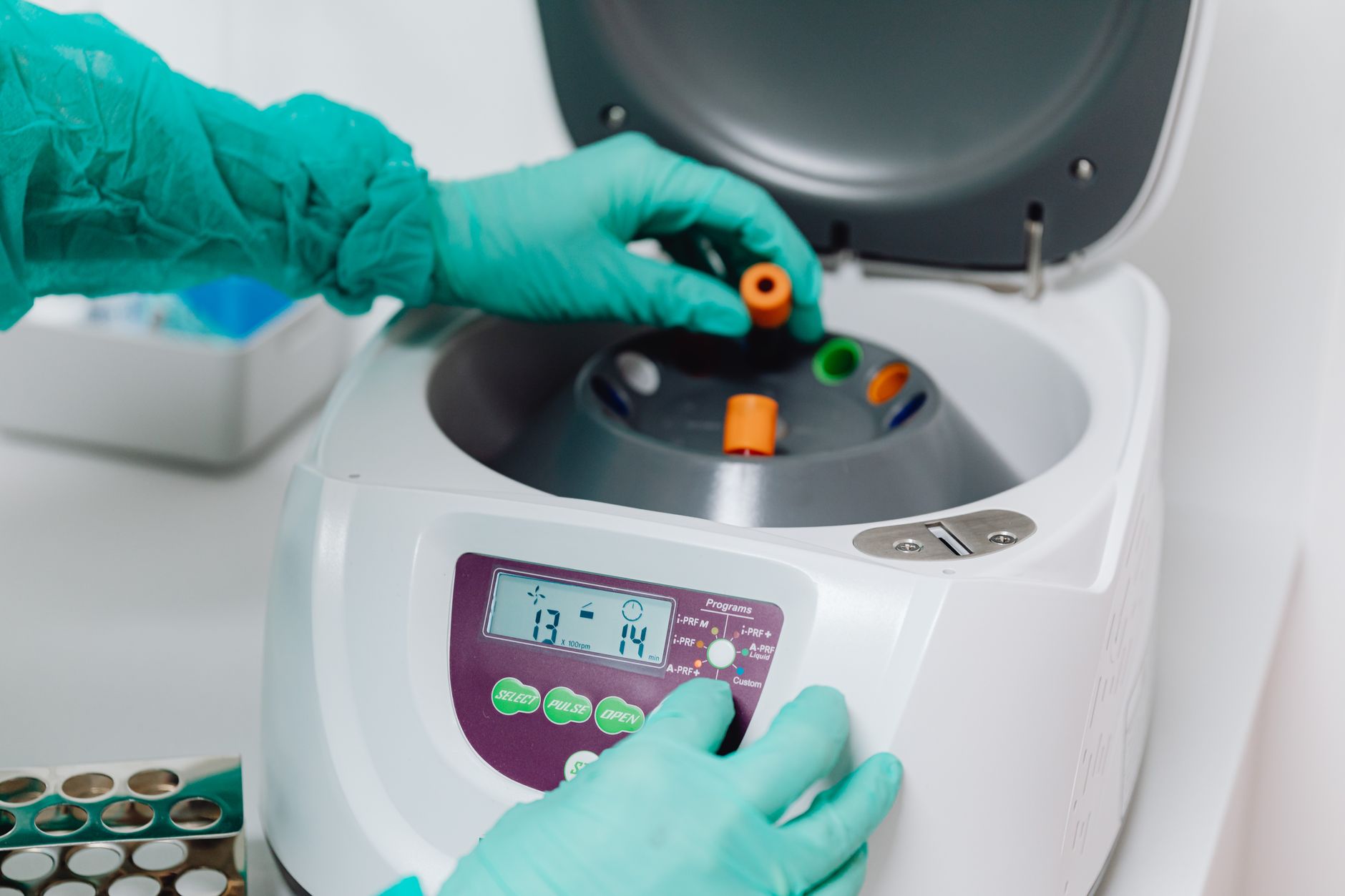 A close-up of a lab technician using a centrifuge to process blood