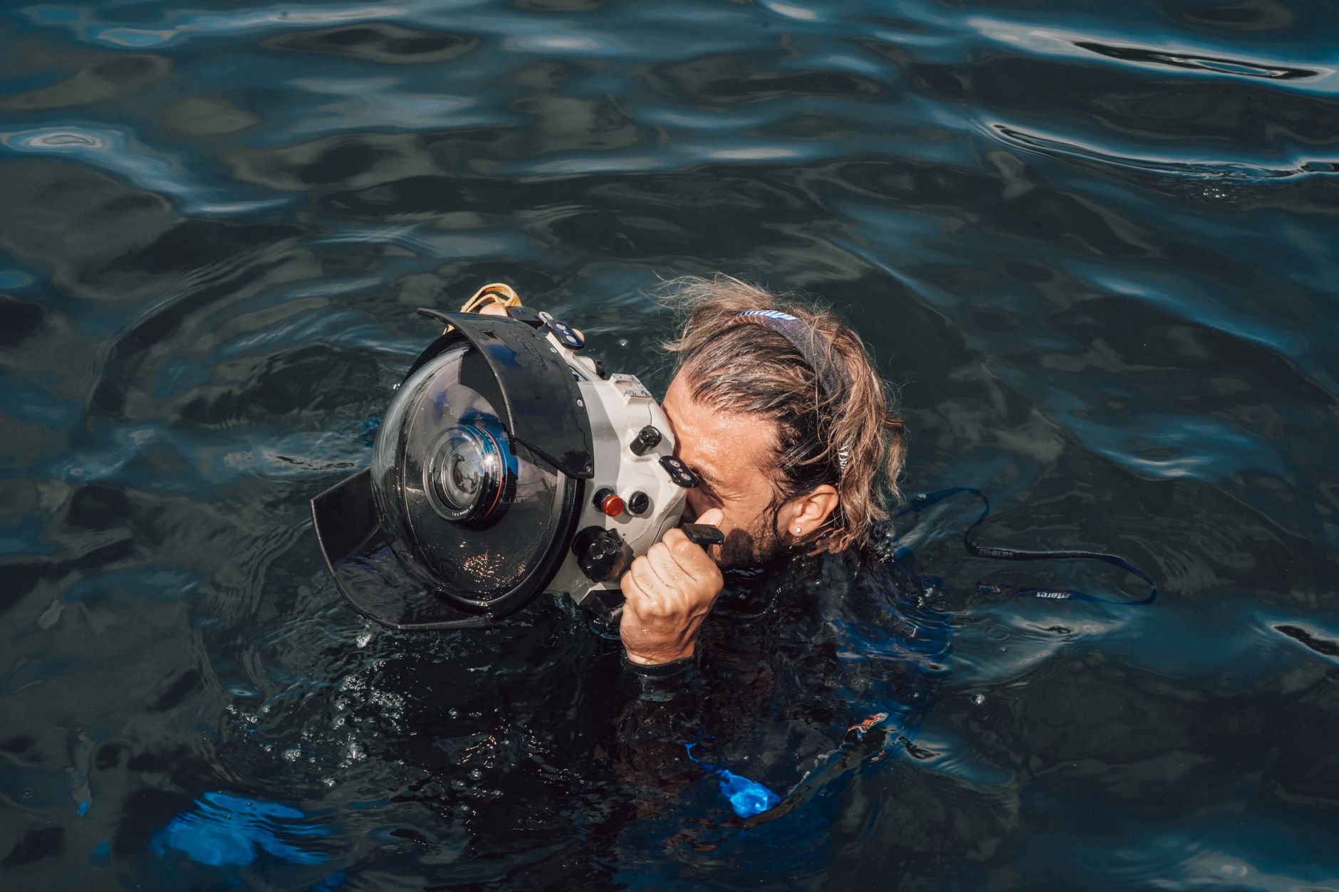 Faceless concentrated diver with wet sandy hair swimming in dark blue reservoir