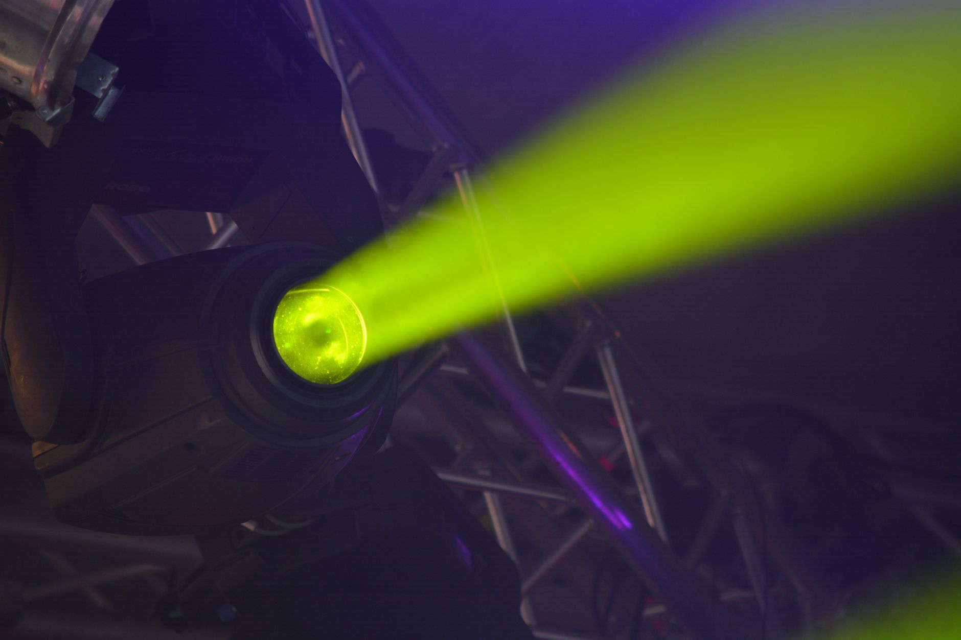 Close-up of a vivid neon spotlight emitting a green beam, part of