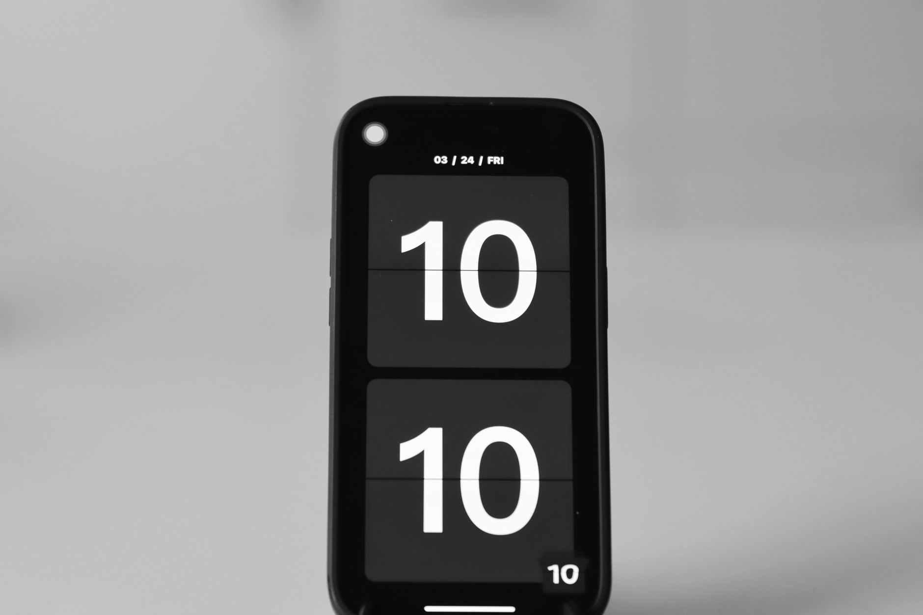 Close-up of a smartphone showing a digital clock set to 10:10 on