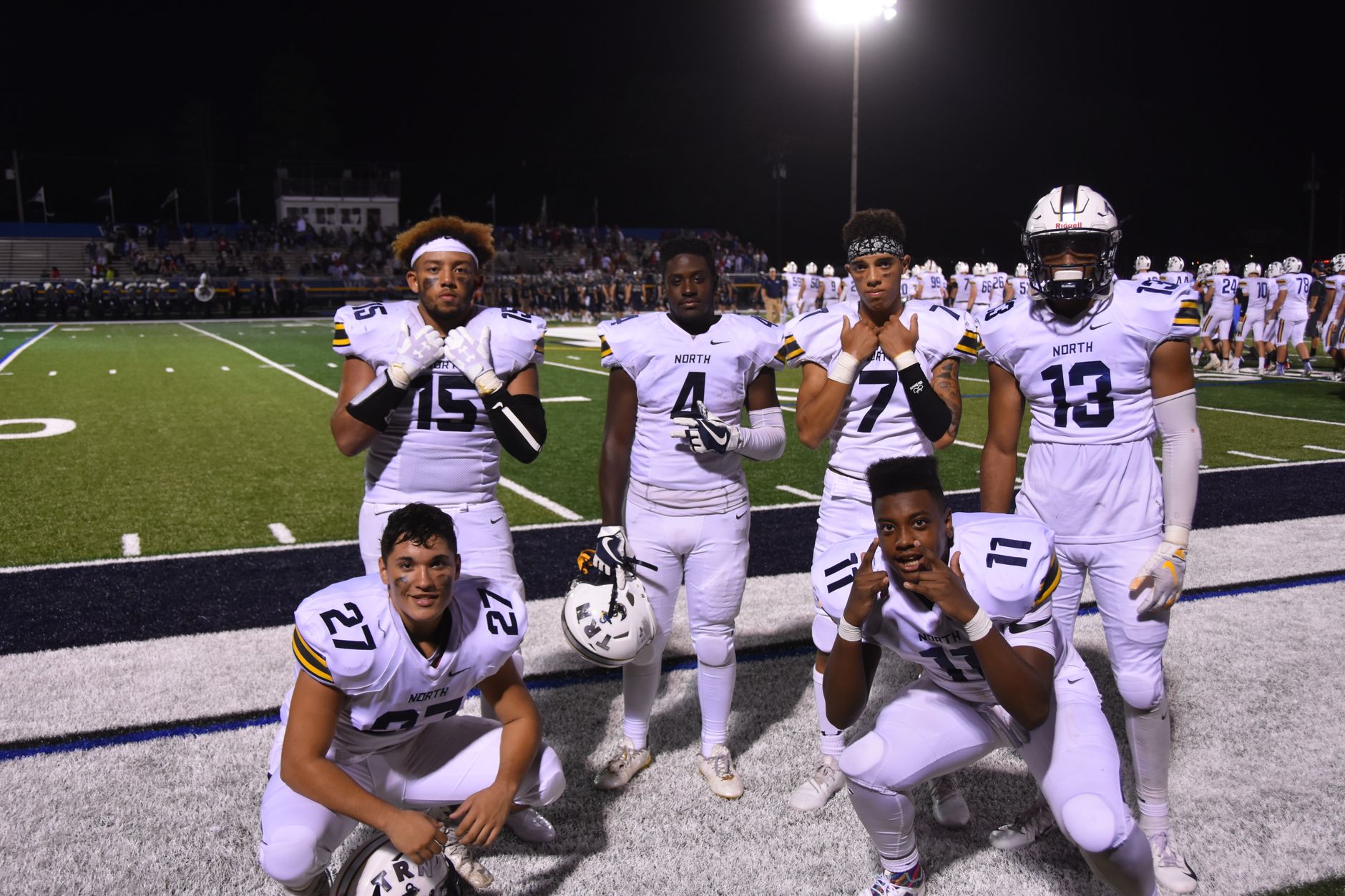 A group of high school football players posing on the field at
