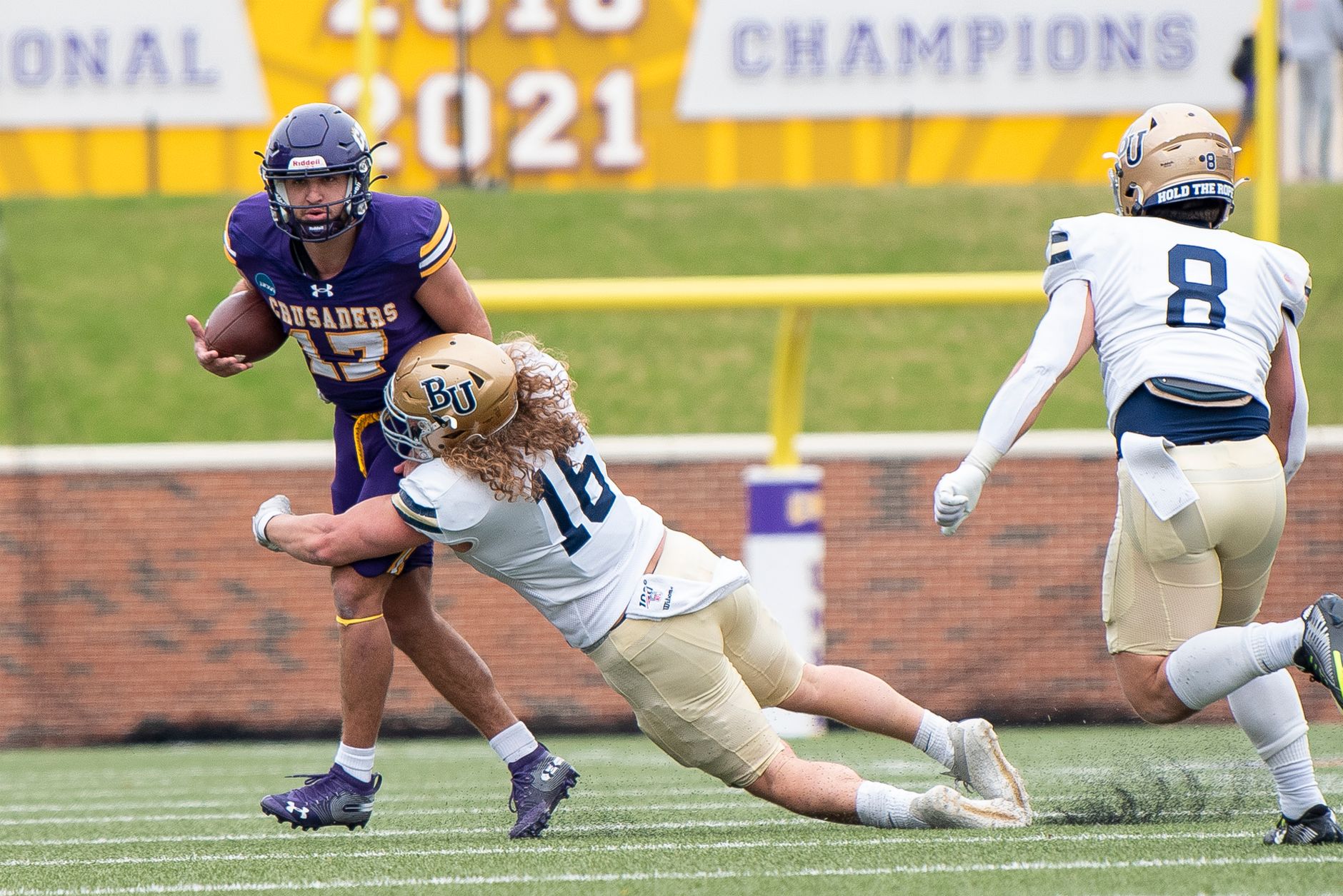 Action shot of a college football game with players in motion on