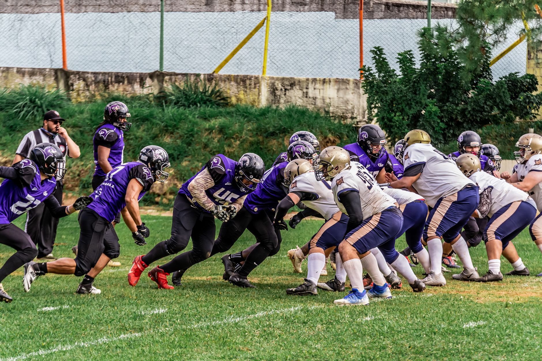 Players in action during an American football game on a grassy field.