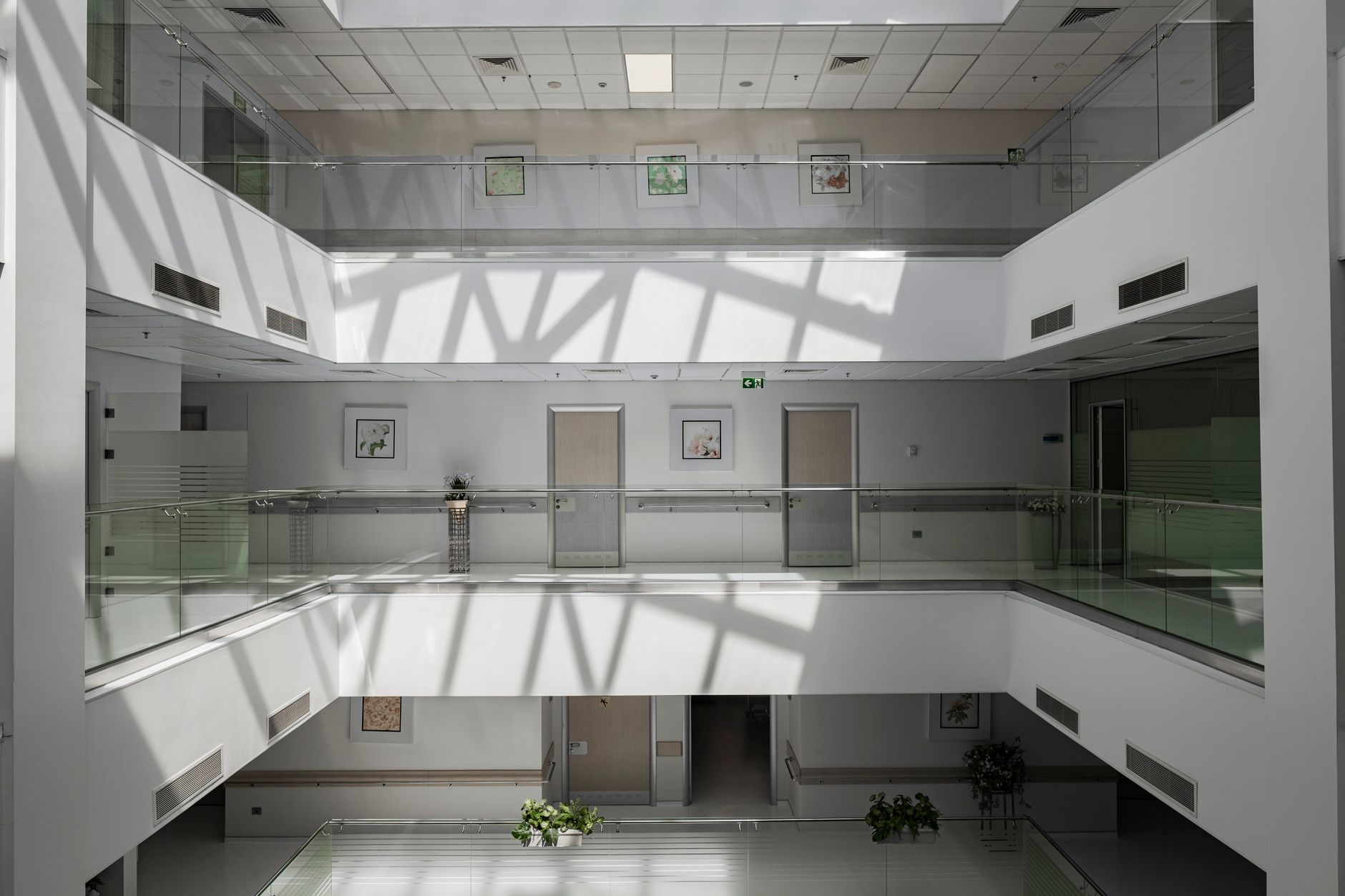 Bright atrium with glass railings and shadows in a modern building in