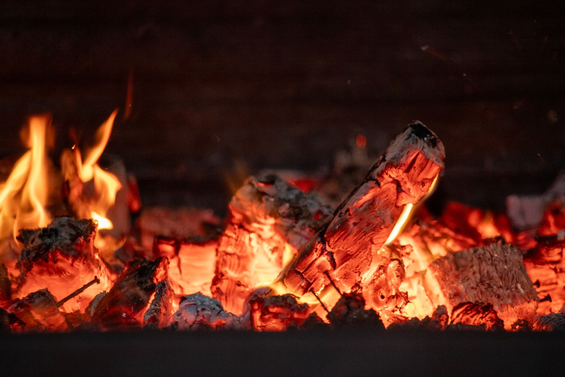Close-up shot of glowing coals in a campfire emitting warmth and vibrant