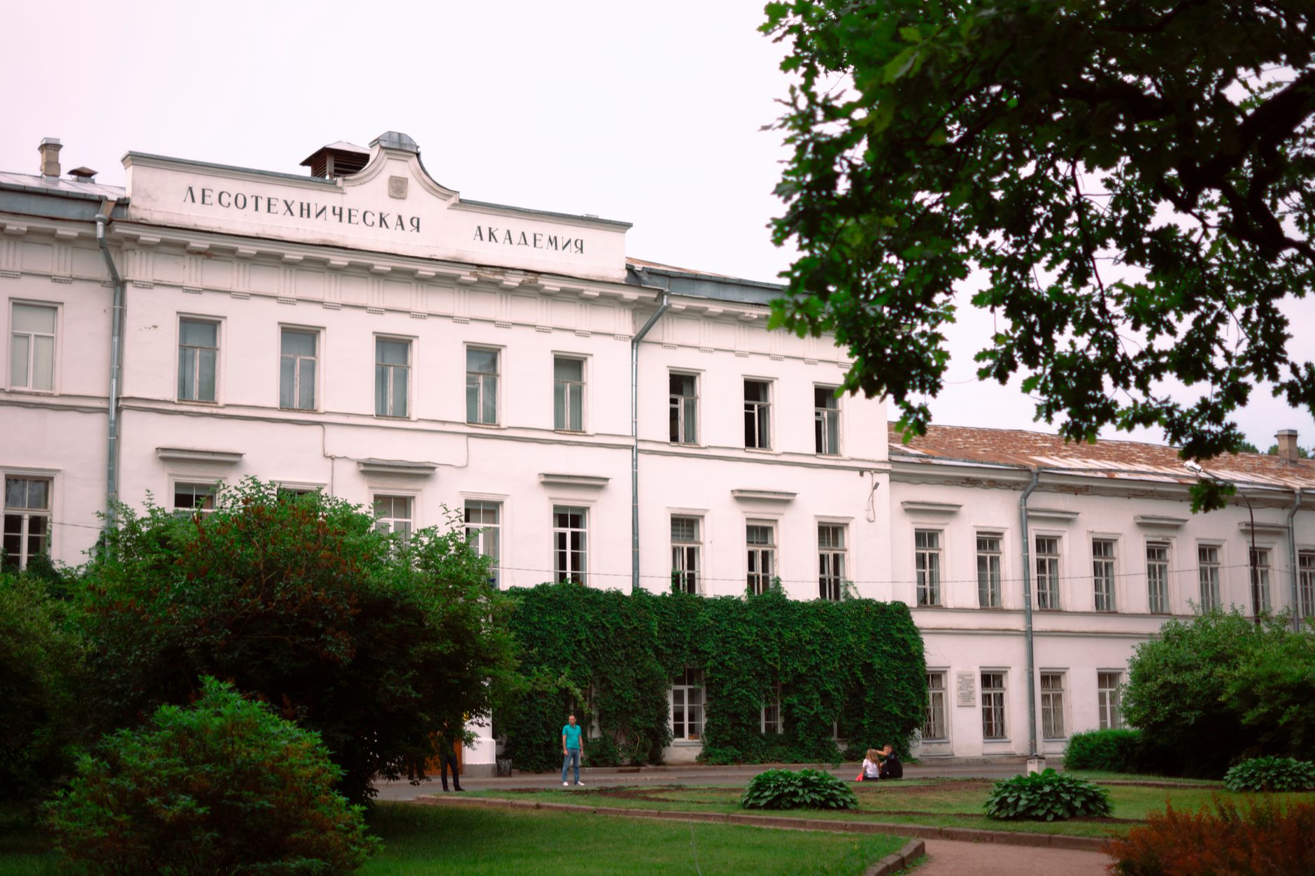 Classic architecture of the Lesotechnic Academy building with lush greenery in Saint Petersburg, Russia.