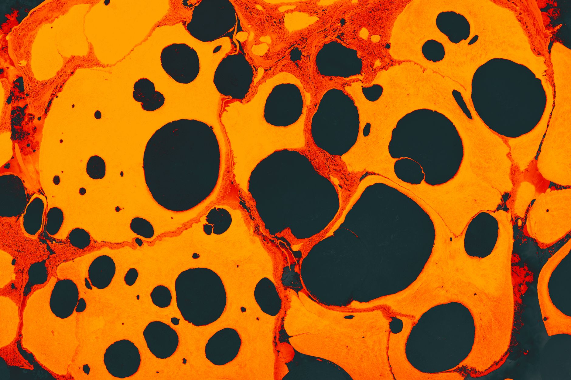 Dynamic abstract image of marbled patterns with vibrant orange and black colors,