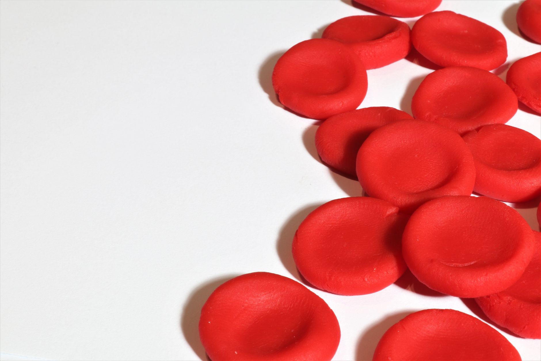 Artistic depiction of red blood cells on a white background, emphasizing medical