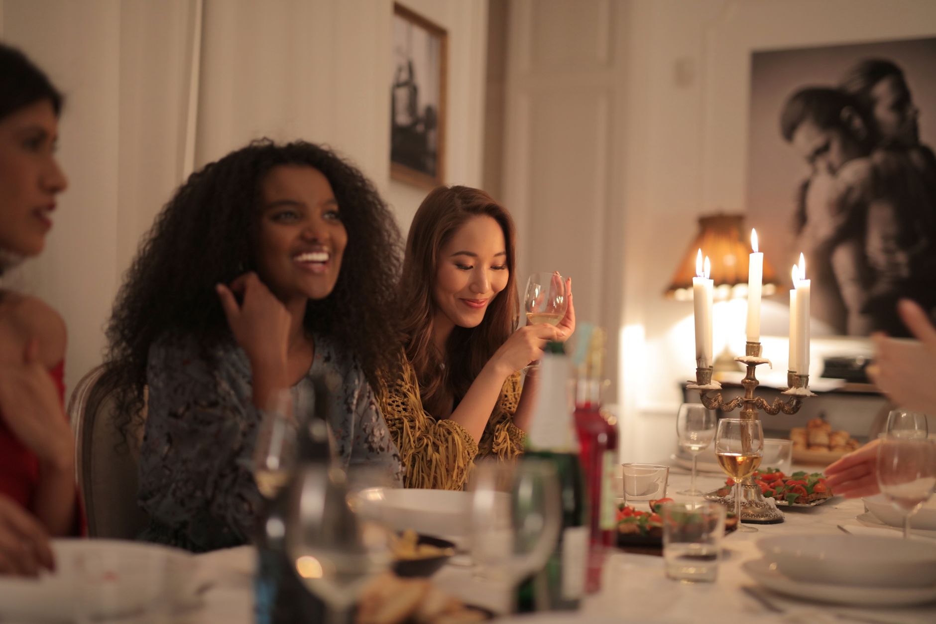 A joyful dinner party indoors with friends enjoying wine and laughter by