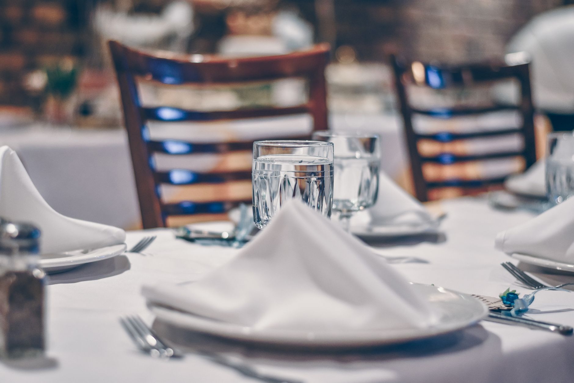 Sophisticated restaurant table setting with crystal glassware and white napkins, perfect for