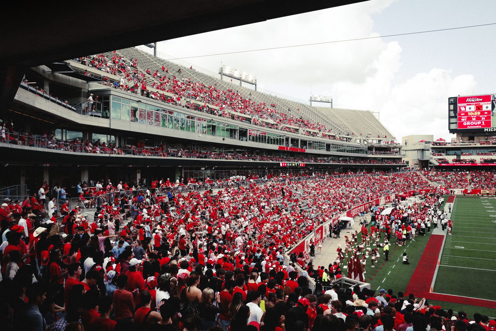 A vibrant crowd in a stadium cheering during an outdoor football game,