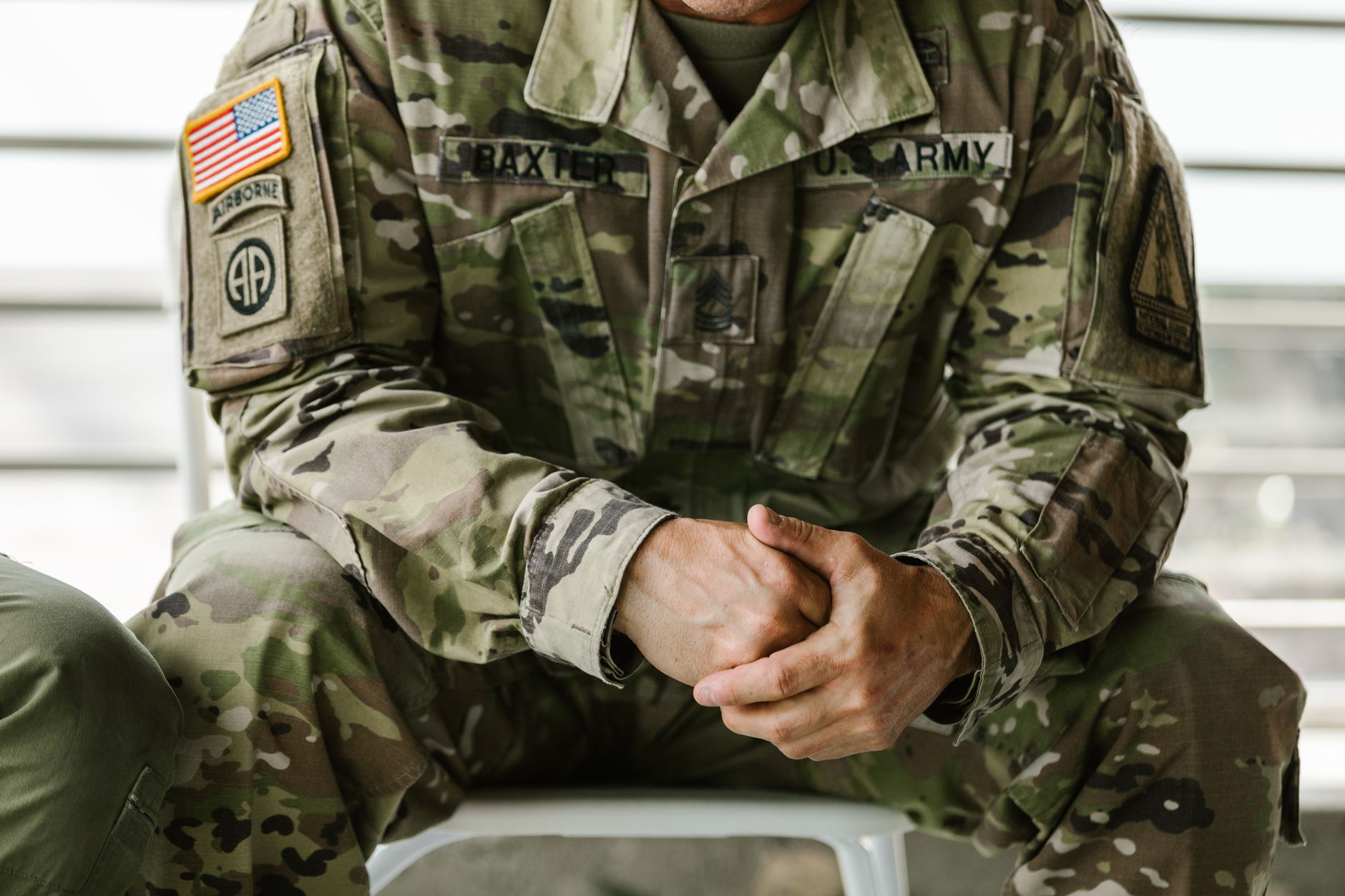 Close-up image of a soldier wearing a camouflage military uniform, displaying patches