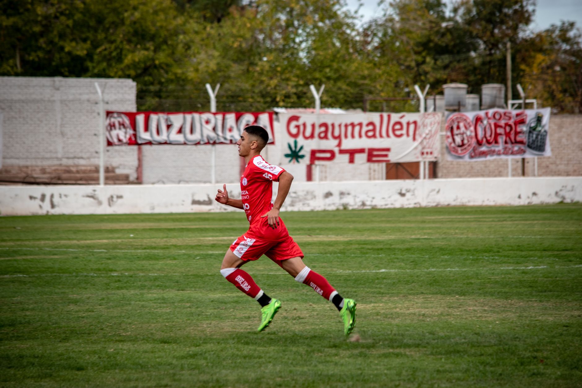 Dynamic shot of a young soccer player running on a football field