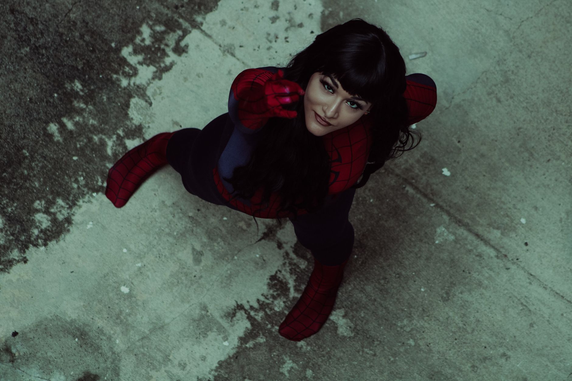 Woman in Spider-Man costume striking a dynamic pose from an overhead view