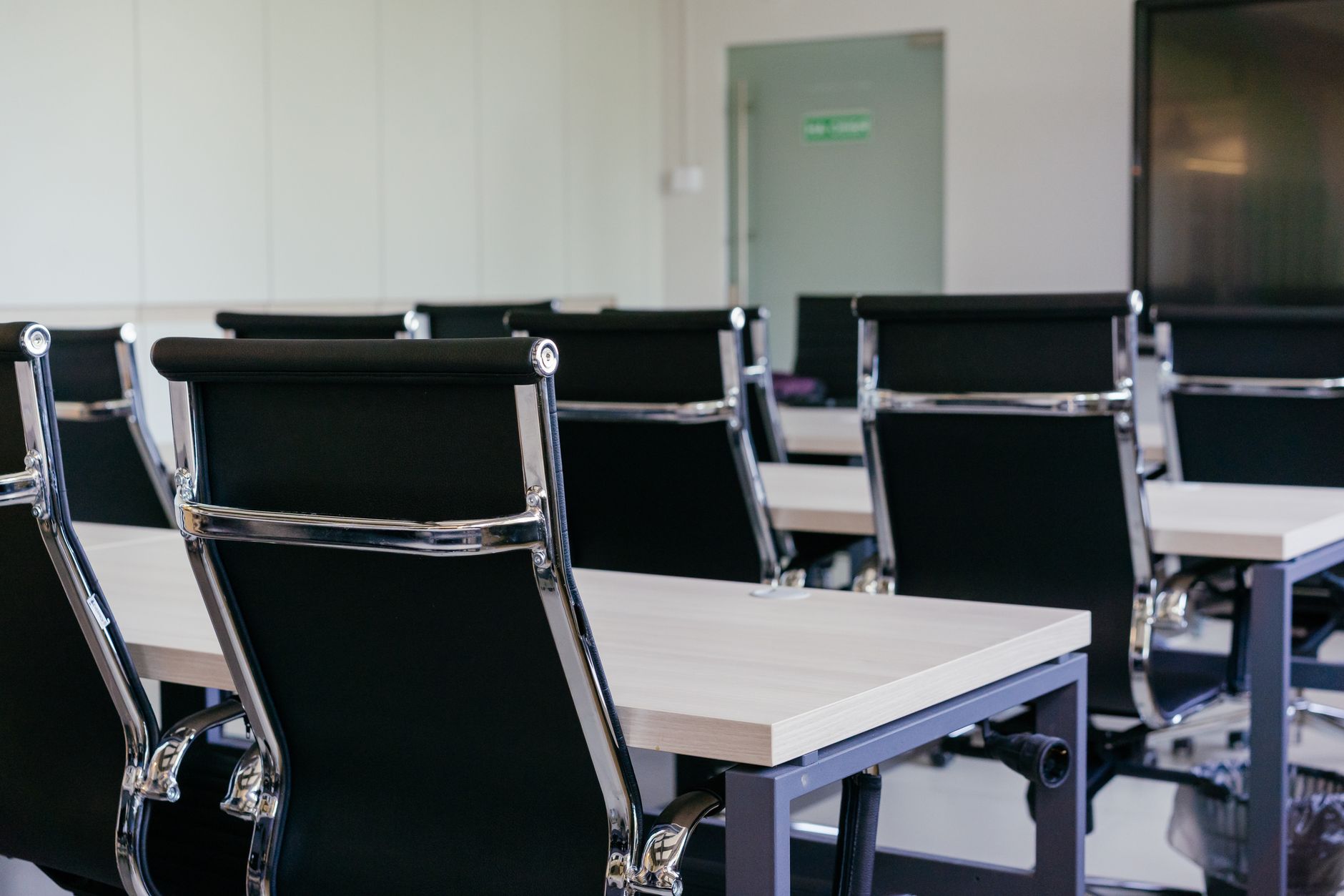 Sleek modern conference room with black chairs and white desks, suitable for