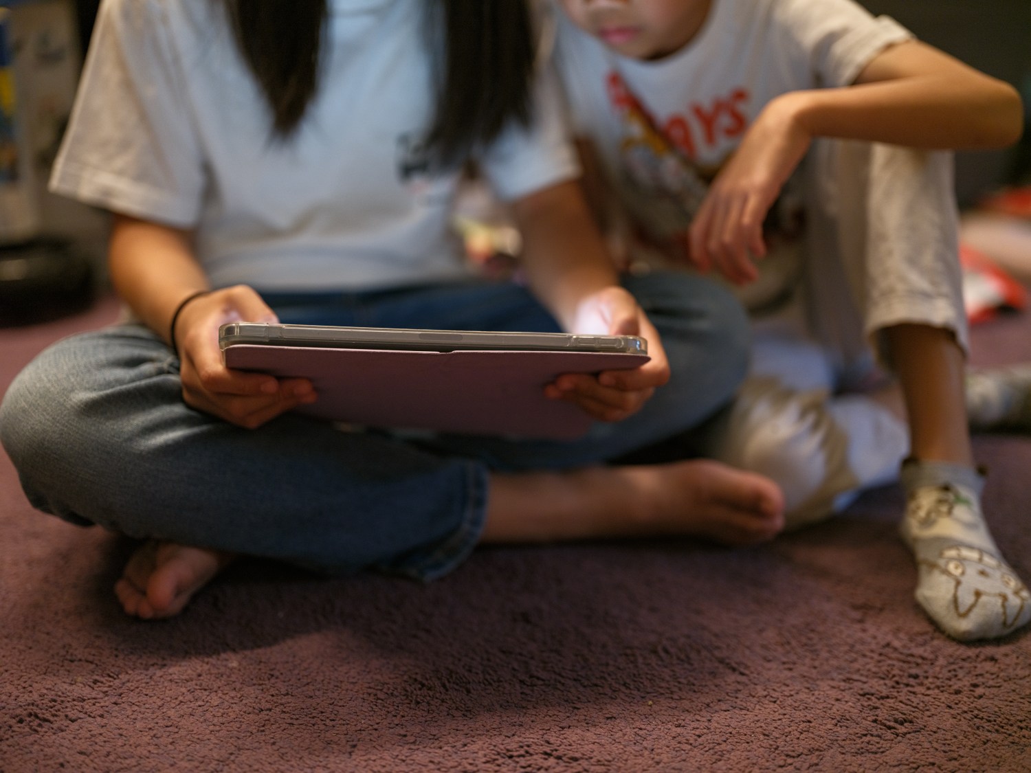 In this file photo, young children look at an iPad screen in Sydney, Australia on Dec. 7, 2025 in Sydney, Australia.