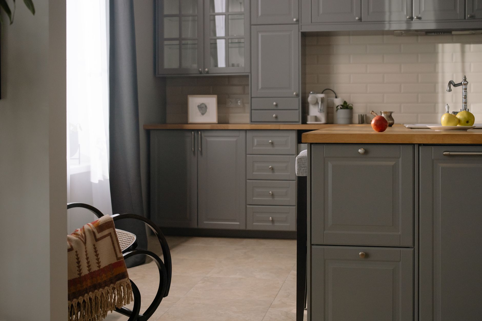 Stylish gray kitchen interior with wooden countertops, natural lighting, and modern design