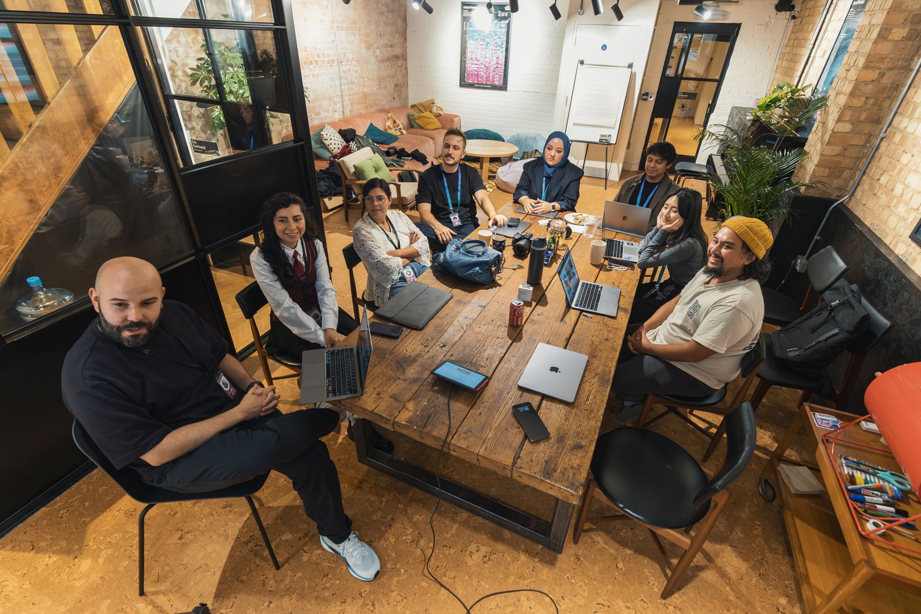 Group of colleagues gathered around a table in a modern office setting,