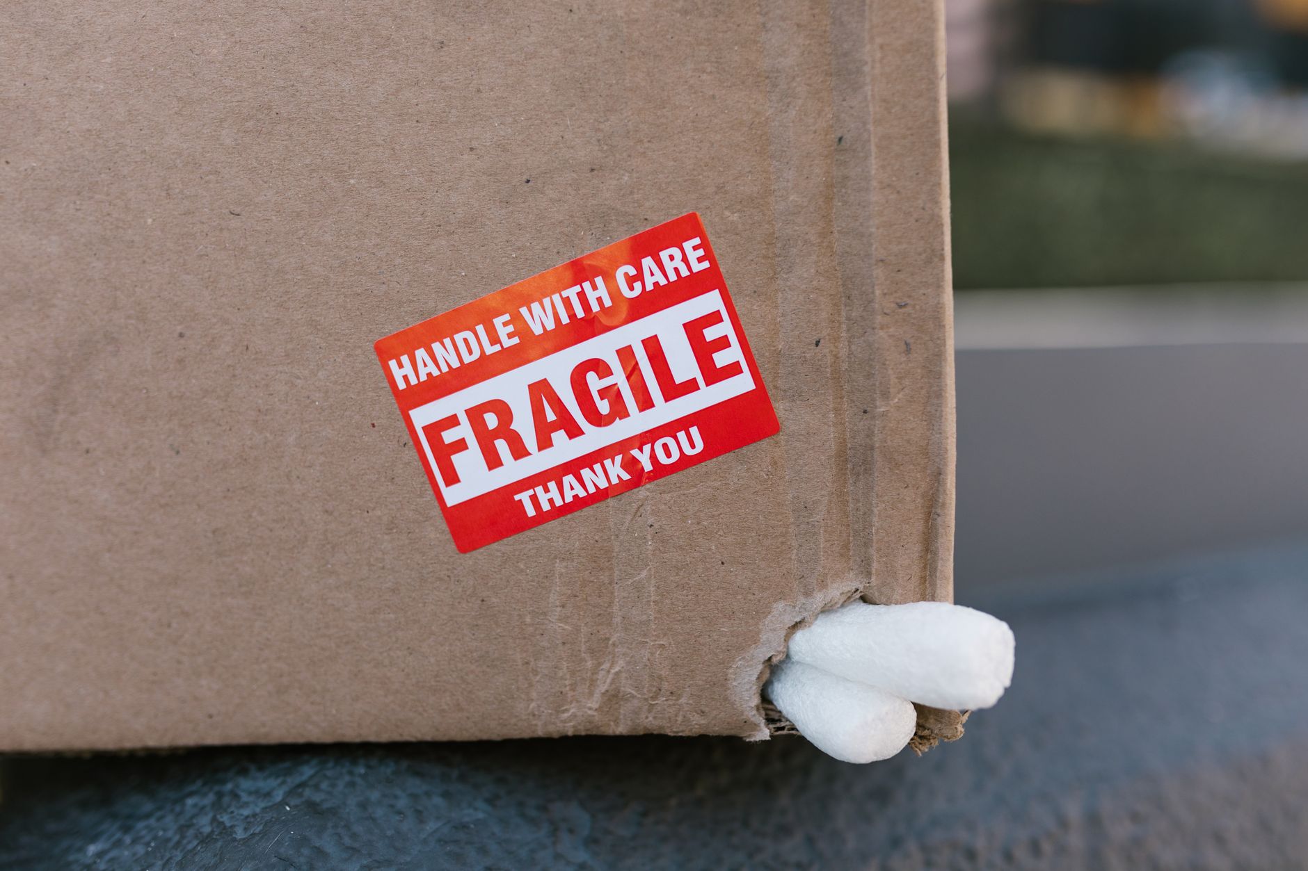 Close-up of a cardboard box with a 'fragile' sticker and packing peanuts