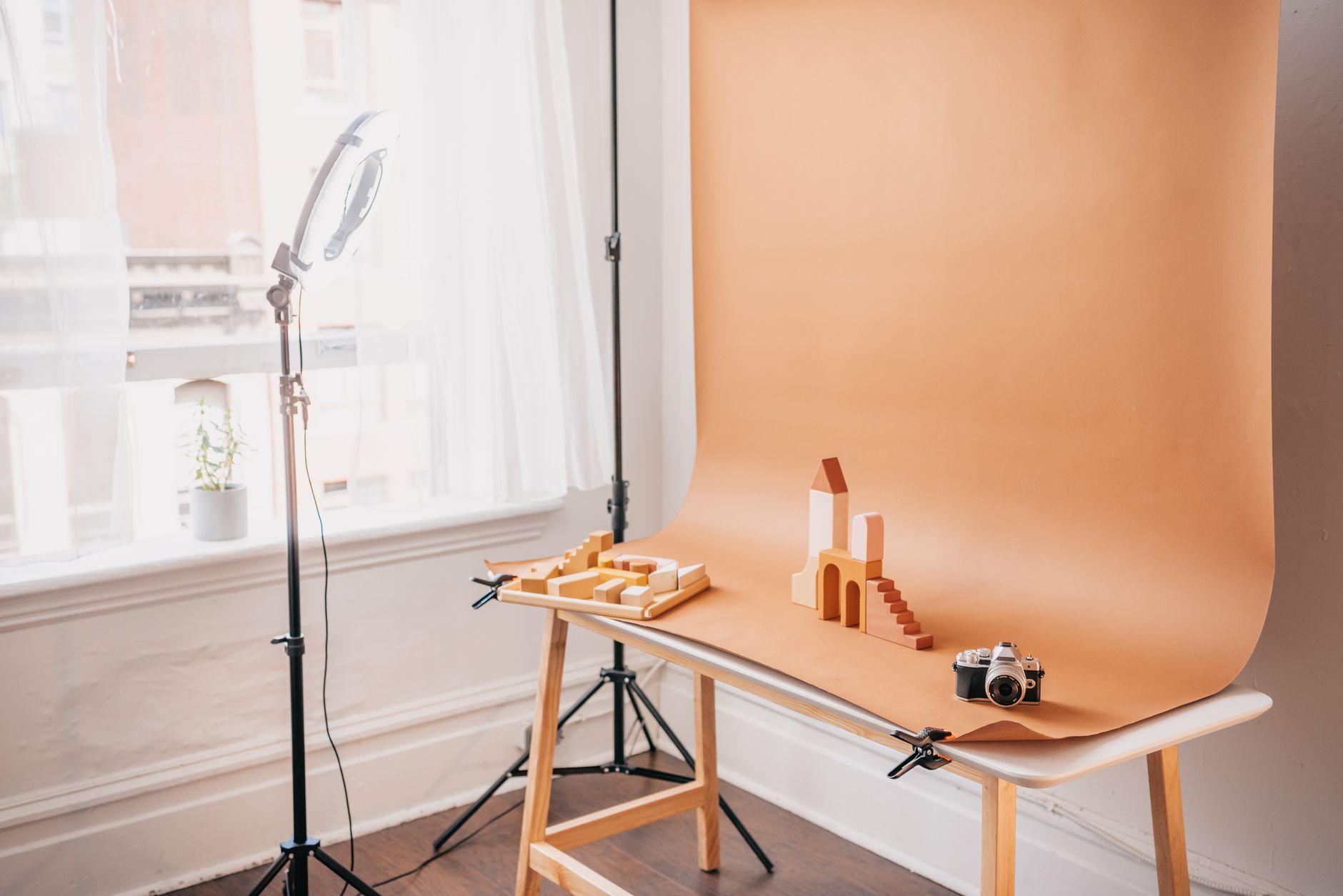 Minimalist studio scene featuring wooden blocks, backdrops, and vintage camera equipment.