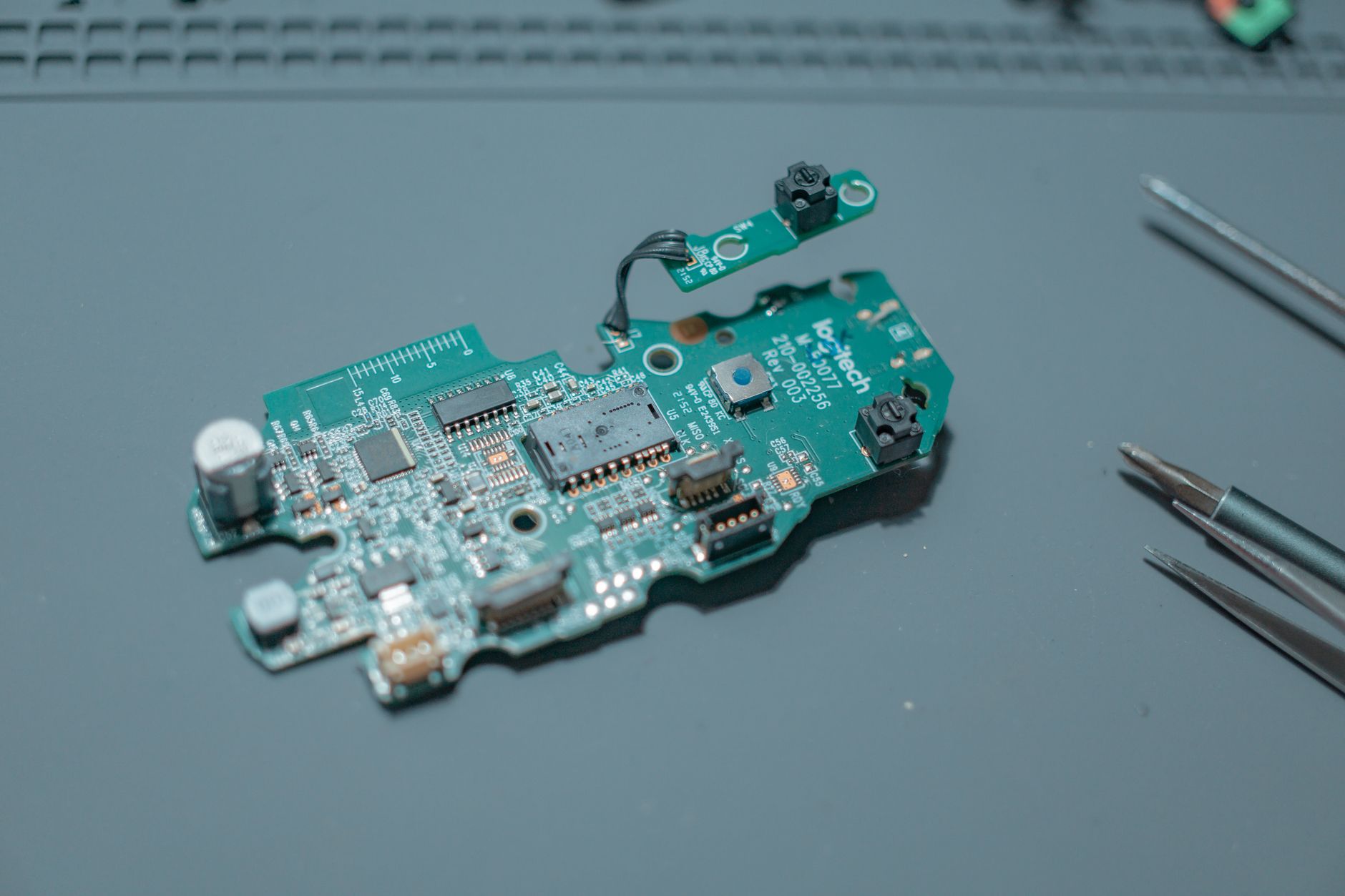 Detailed view of a circuit board with electronic components and tools.
