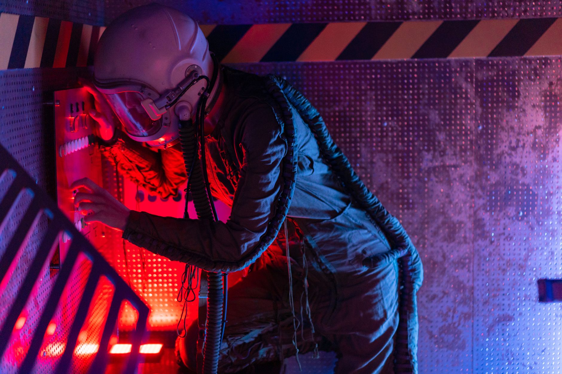 A woman in a spacesuit operates a futuristic control panel, bathed in