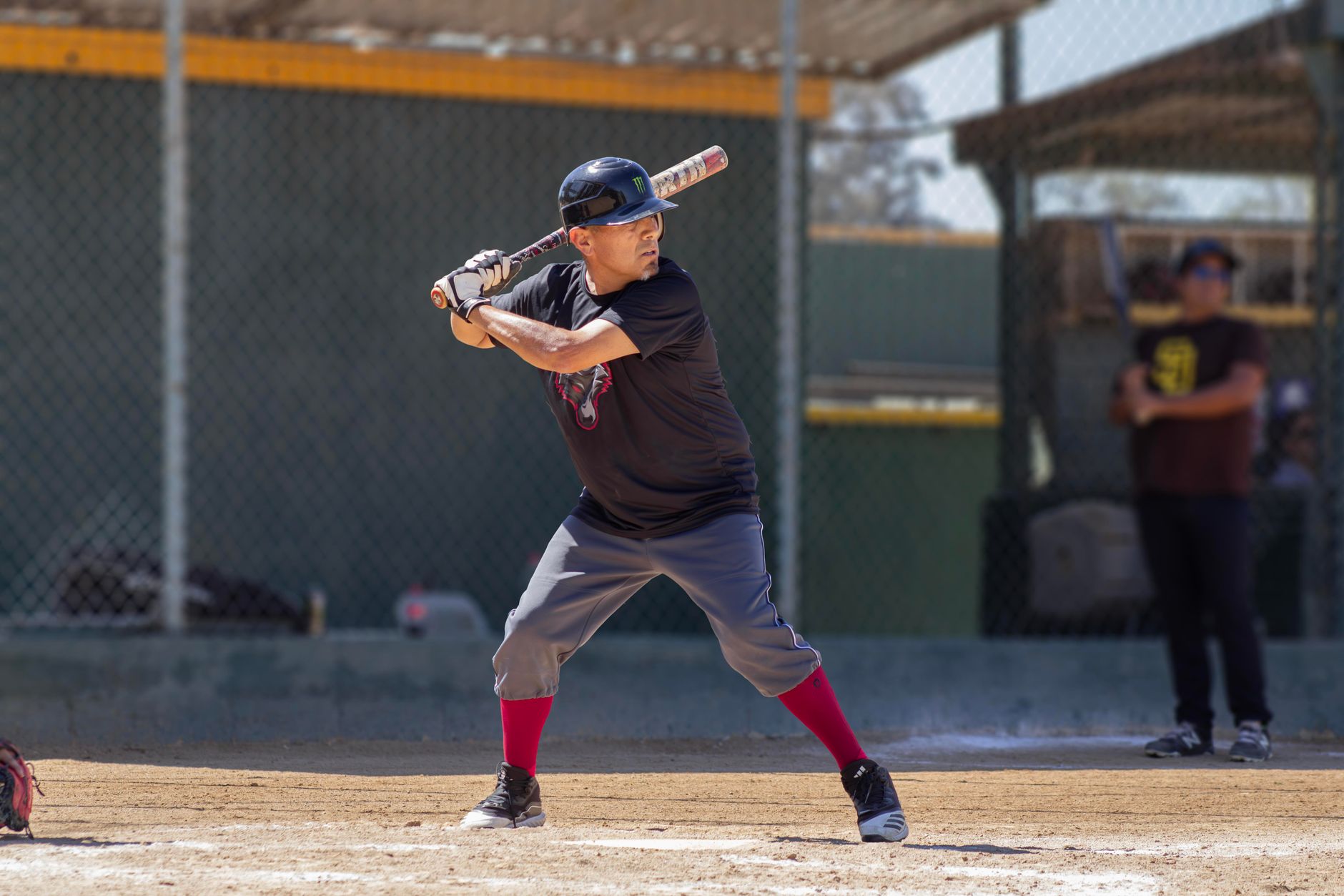 A baseball player in mid-swing during an outdoor game, showcasing athletic skills
