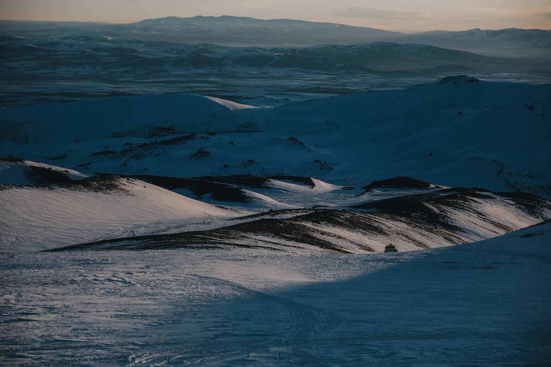 Expansive snowy mountain view at twilight offering serene and dramatic scenery.