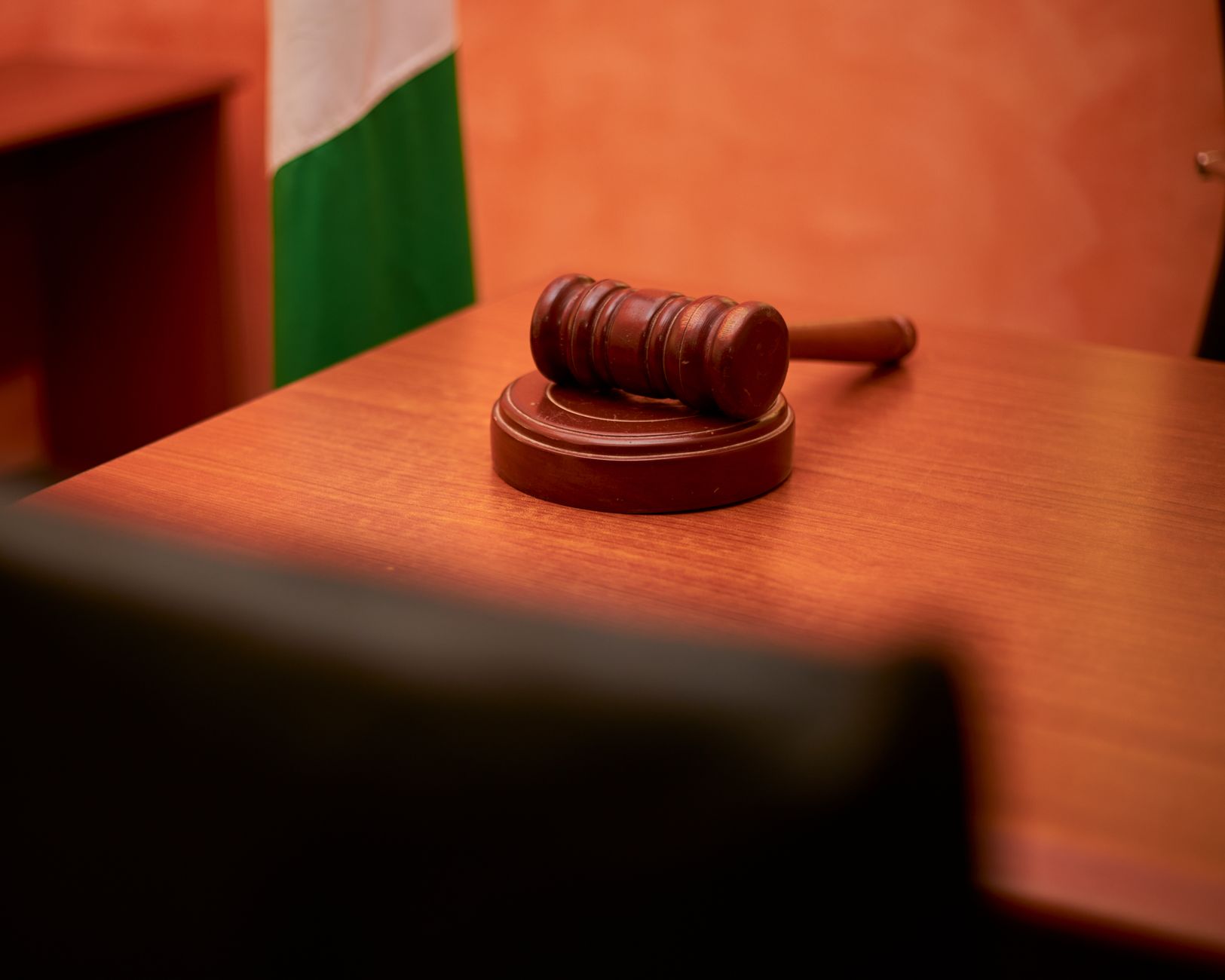 A close-up of a gavel on a courtroom desk representing law and