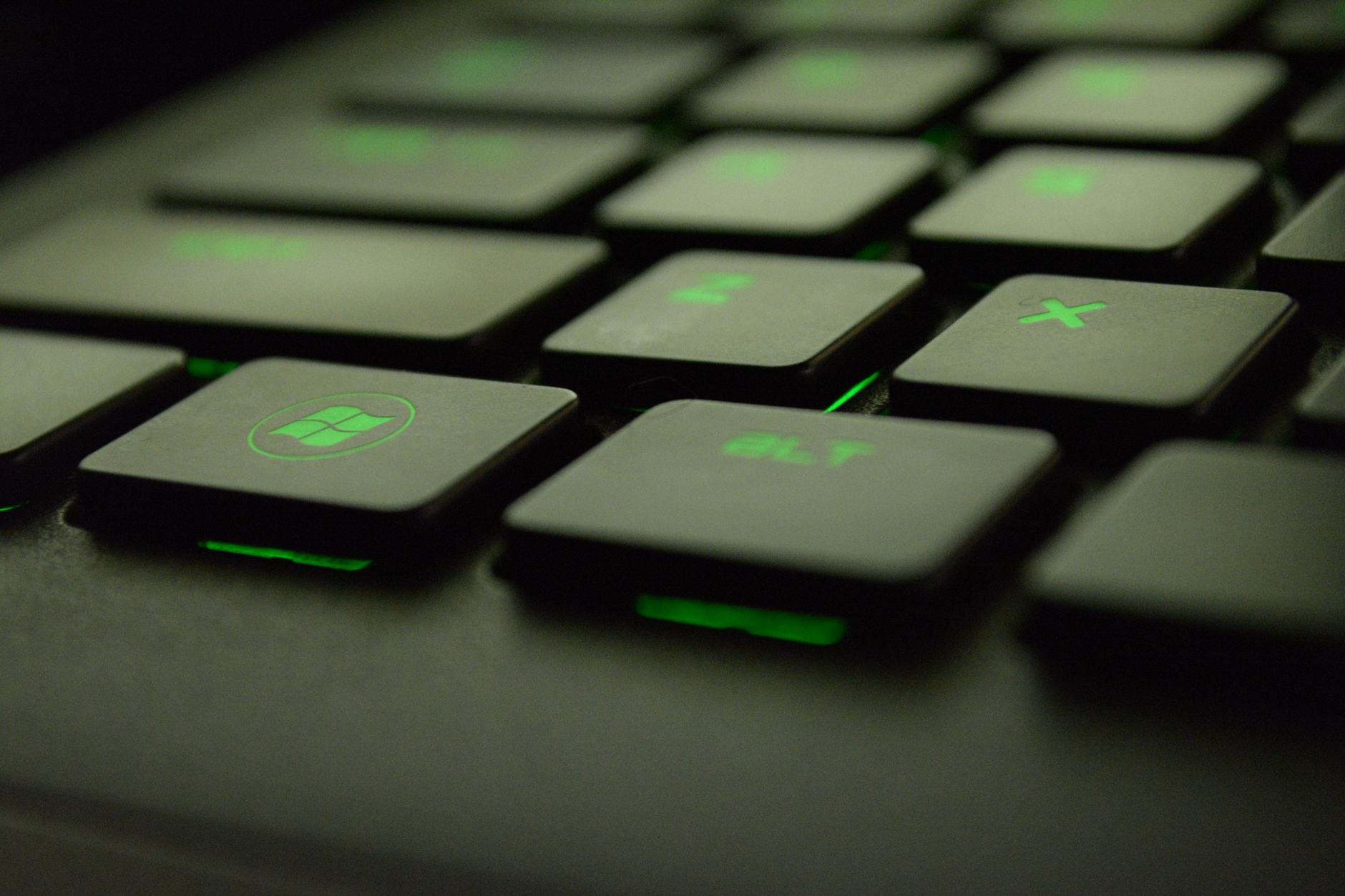 Detailed view of illuminated backlit keyboard keys with green lighting for gaming
