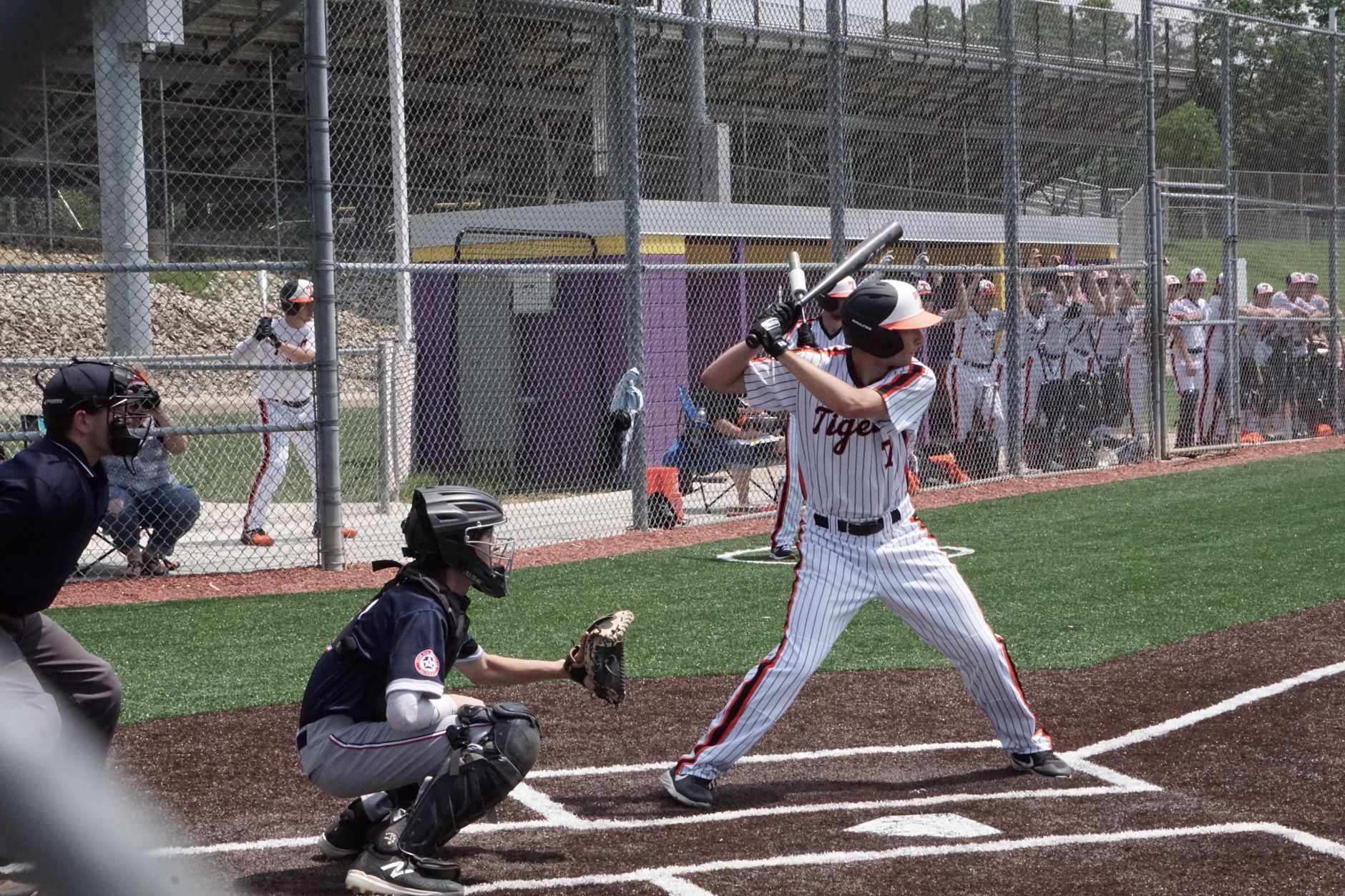 A batter prepares to hit during a high school baseball game. Players