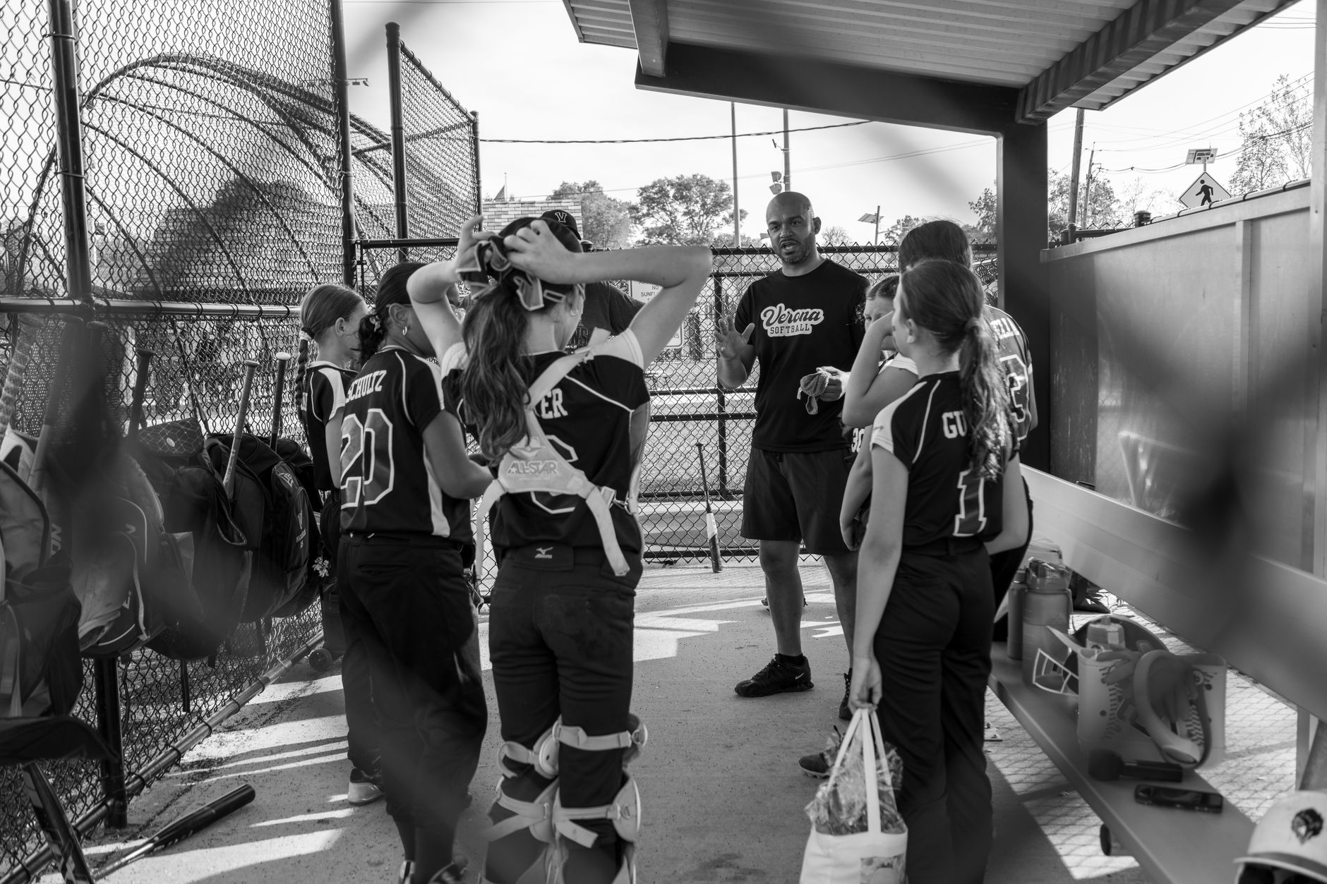 A youth softball coach gives a team talk to players in a