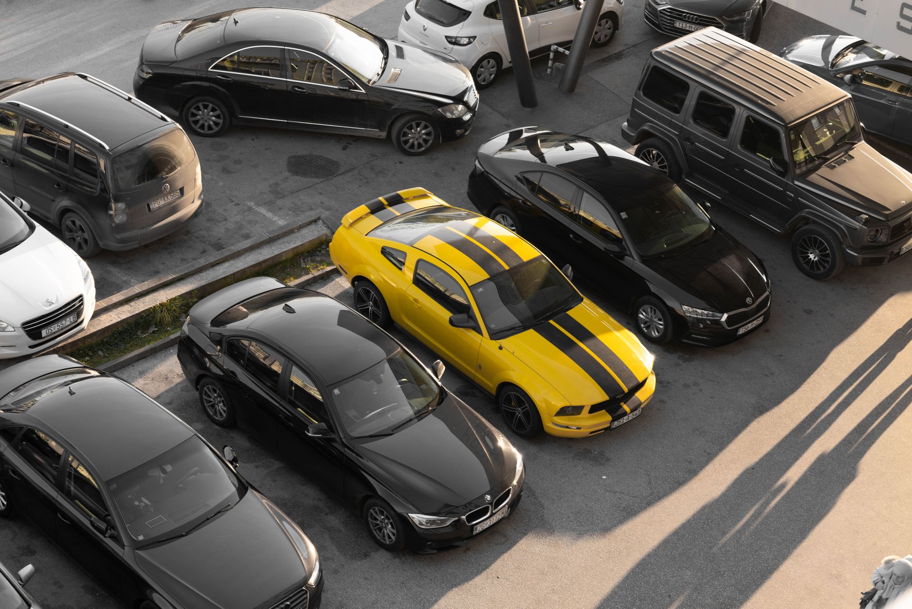 Top view of various cars parked in a parking lot, featuring a